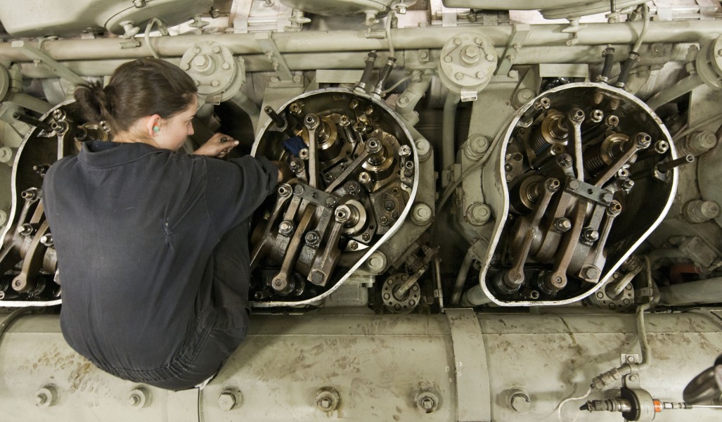 US Navy 120124-N-PB383-789 Engineman Fireman Recruit Megan Cotrell conducts maintenance on an engine in one of the main spaces aboard the amphibiou