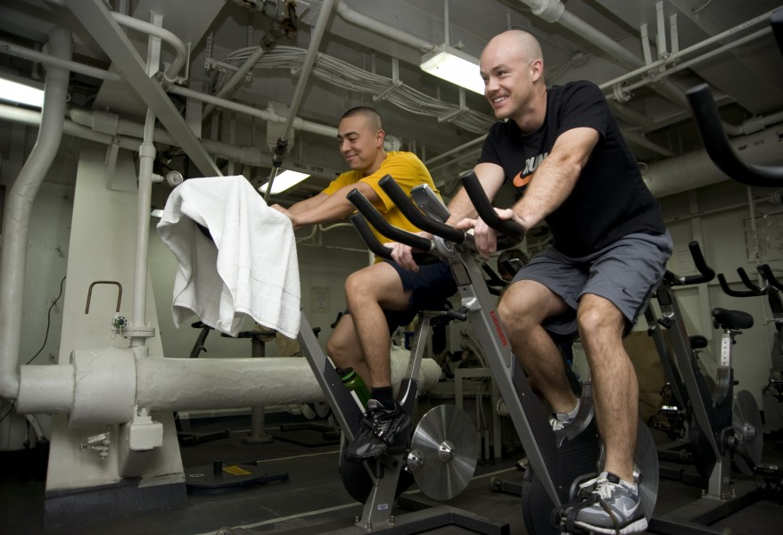 US Navy 120208-N-JN664-008 Chief Aviation Boatswain's Mate (Fuel) Richard Palmer participates in a spinning class aboard the Nimitz-class aircraft 