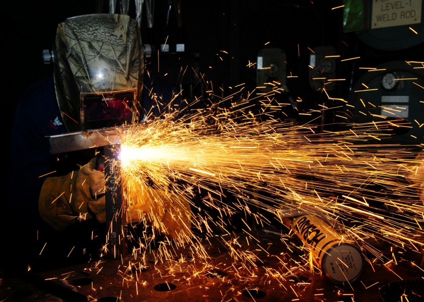US Navy 120209-N-SK590-014 ull Maintenance Technician 2nd Class Ben Vigness welds scrap metal aboard the Nimitz-class aircraft carrier USS Abraham 