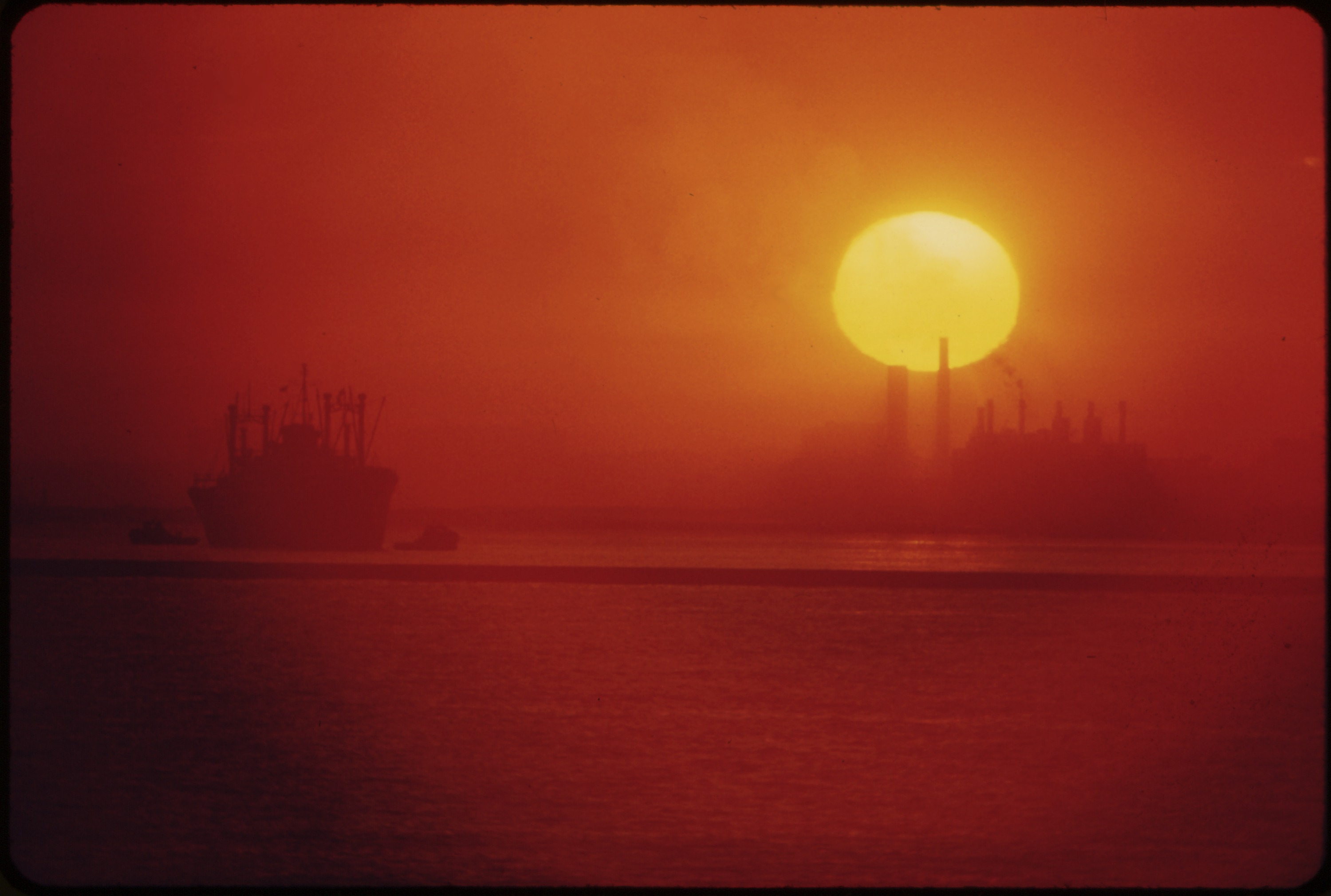 THE SUN RISES OVER CLEVELAND'S SMOG-OBSCURED SKYLINE - NARA - 550304