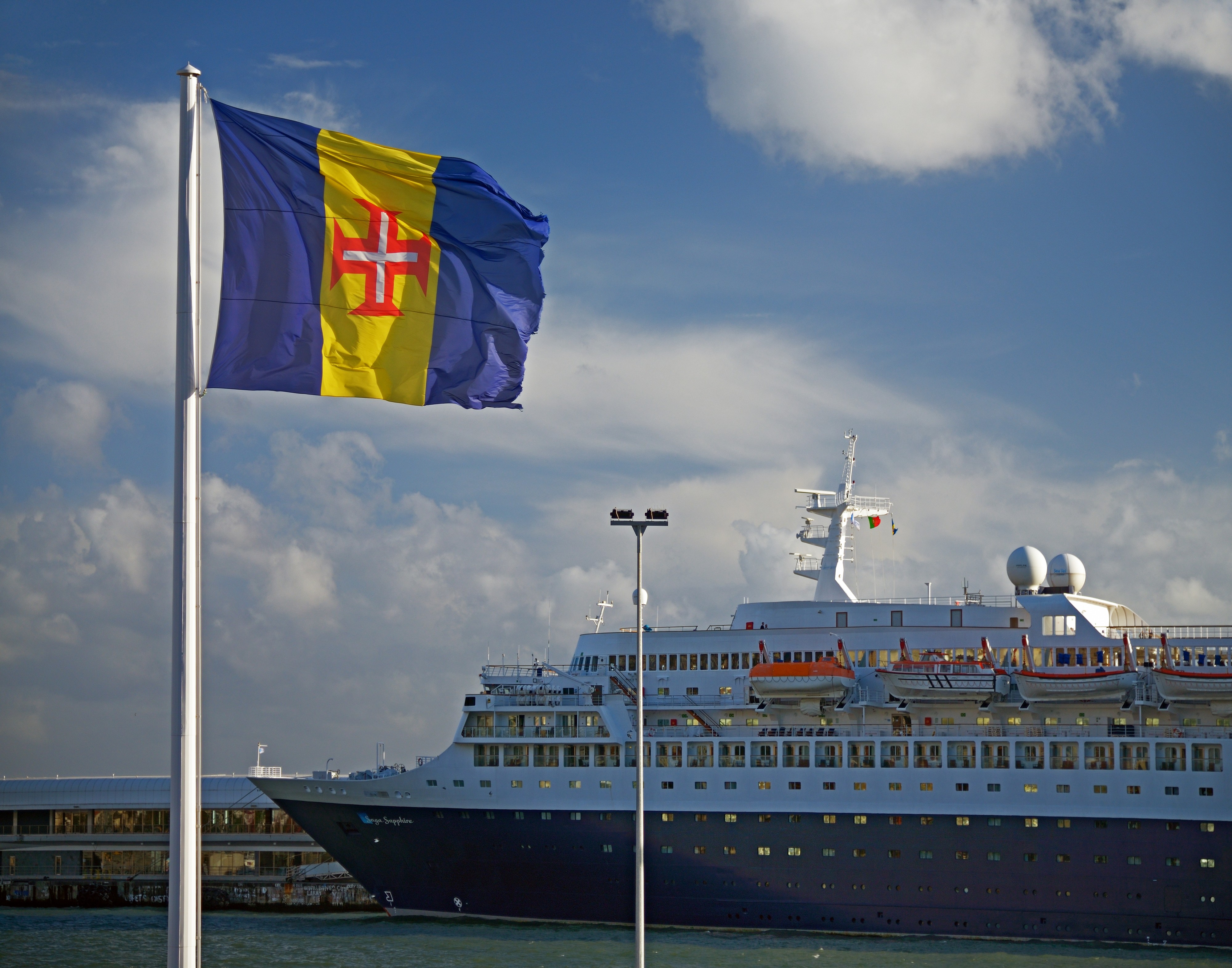 Flag of Madeira and Saga Sapphire in the port of Funchal. Madeira, Portugal