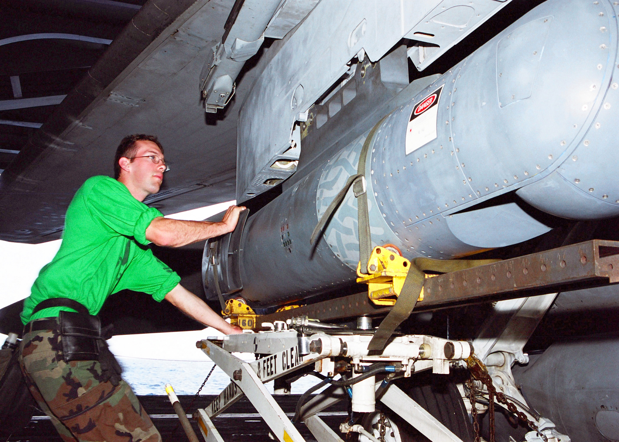 US Navy 030122-N-9403F-002 Electronics Technician 2nd Class Michael Weston of Sedley, Calif., loads a Forward Looking Infrared (FLIR) pod under the wing of an F-14D Tomcat fighter aircraft