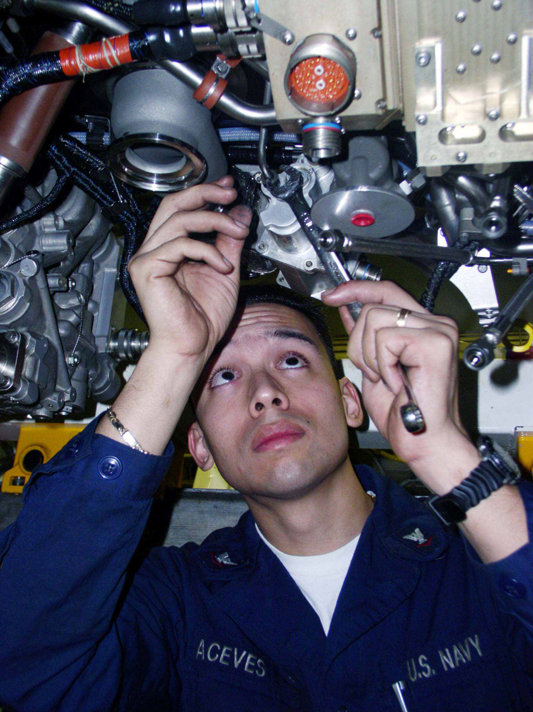 US Navy 030210-N-9228K-015 Aviation Machinist's Mate 3rd Class Anthony Aceves torques a nut on the engine of an F-A-18E Super Hornet
