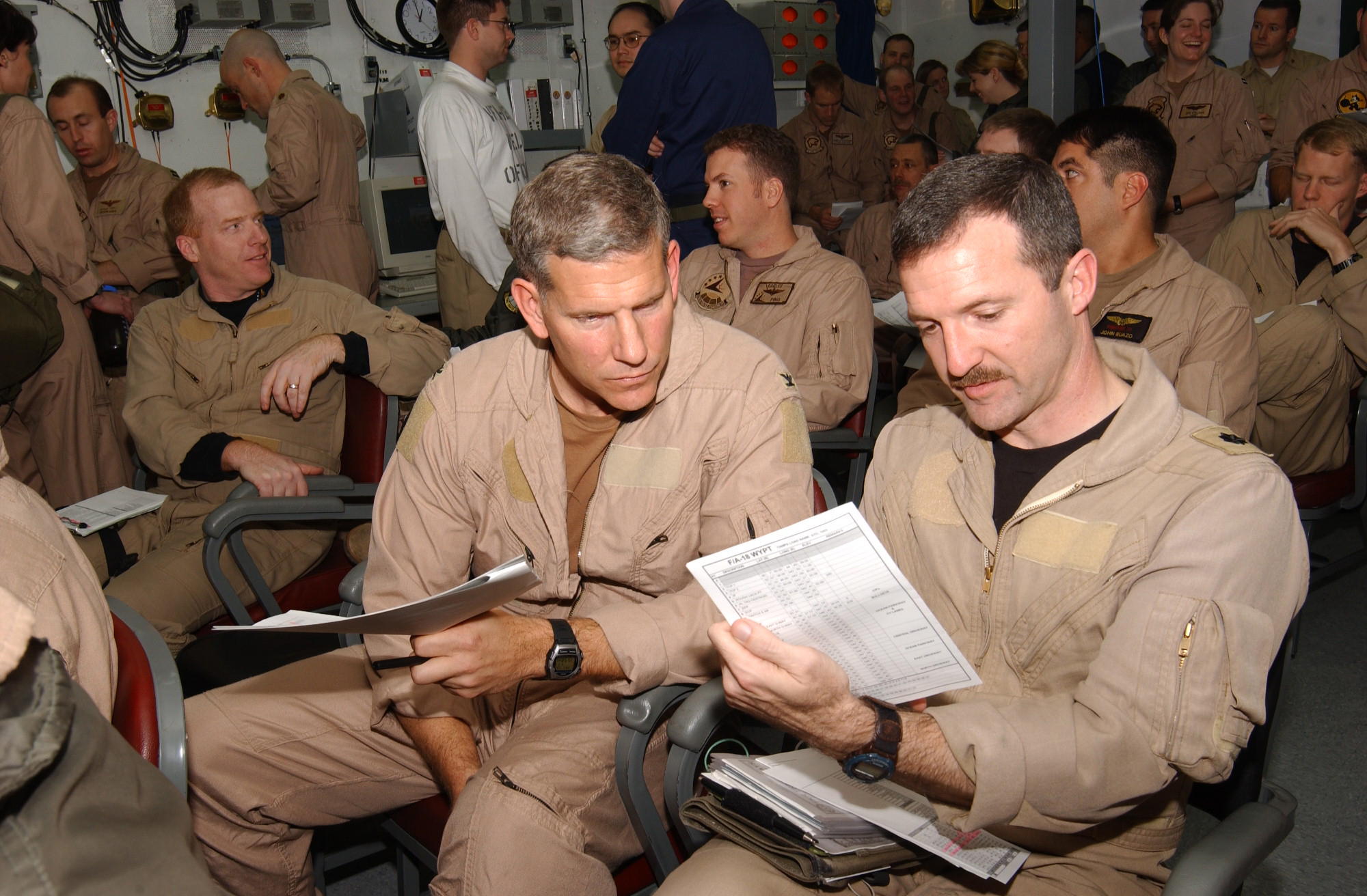 US Navy 030323-N-5932S-007 Two Naval Aviators assigned to Carrier Air Wing Fourteen (CVW-14) prepare for a brief in a squadron ready room aboard the aircraft carrier USS Abraham Lincoln (CVN 72)