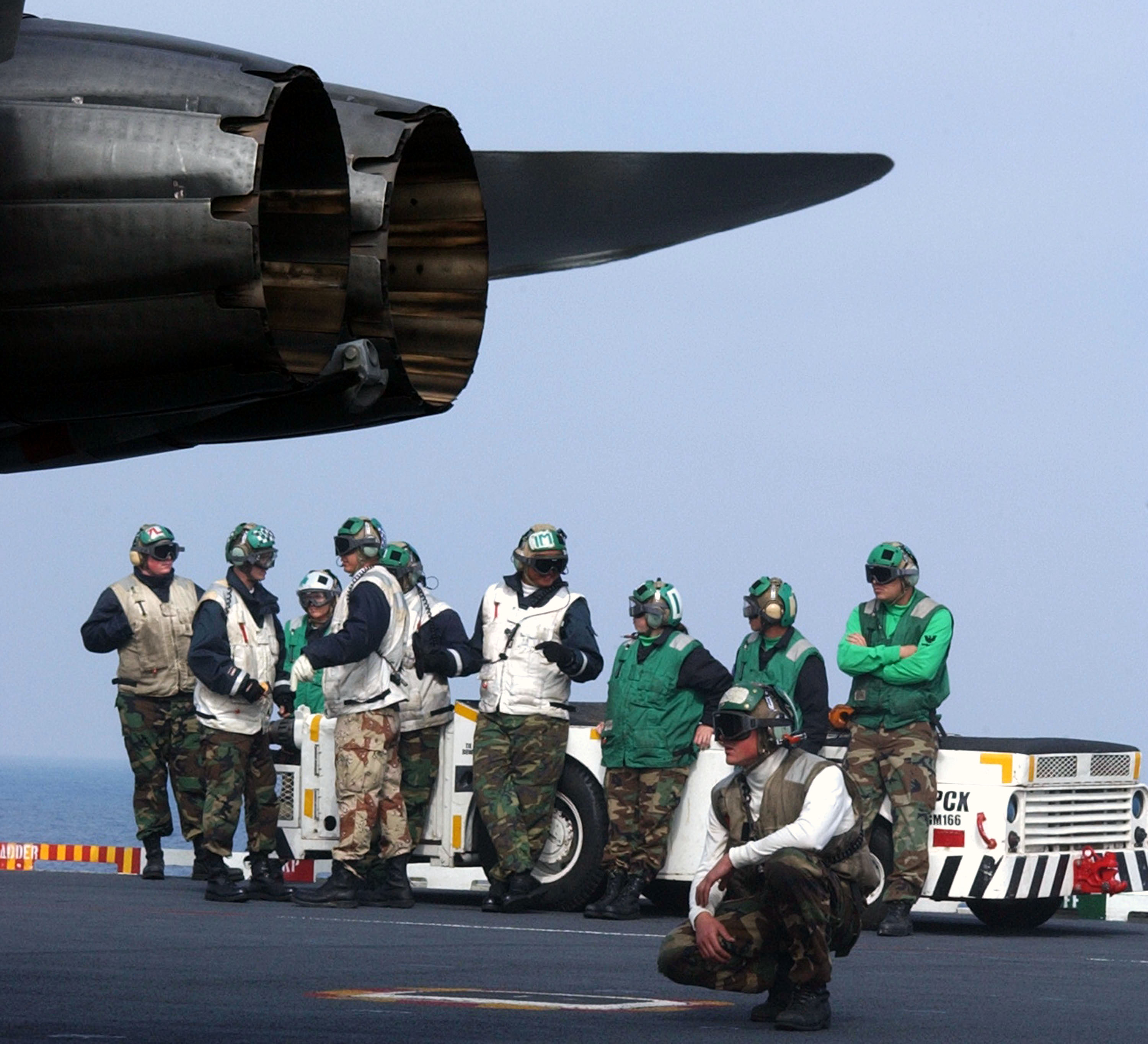 US Navy 030325-N-9060G-021 Flight deck personnel stand by as an F-A-18 Hornet is prepared to launch