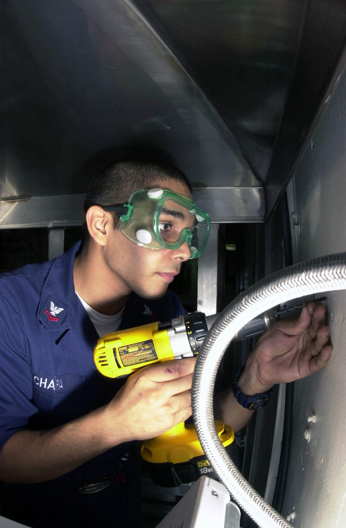 US Navy 030401-N-1577S-002 Hull Technician 2nd Class David Chapa from Pleasanton, Texas, lines up his drill to begin installation of an electrical outlet aboard USS Nimitz (CVN 68)
