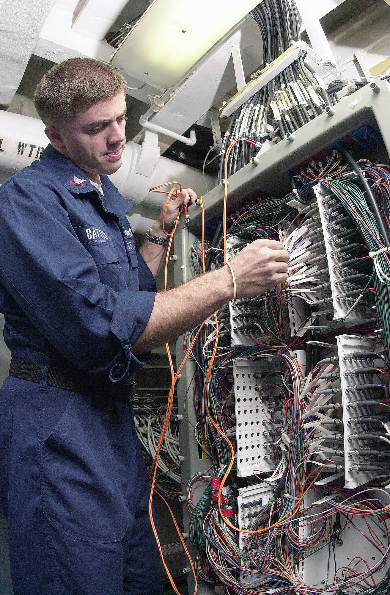 US Navy 030502-N-0413R-002 Information Technician 2nd Class George Battistell repairs Local Area Network (LAN) connections aboard the aircraft carrier USS Nimitz (CVN 68)