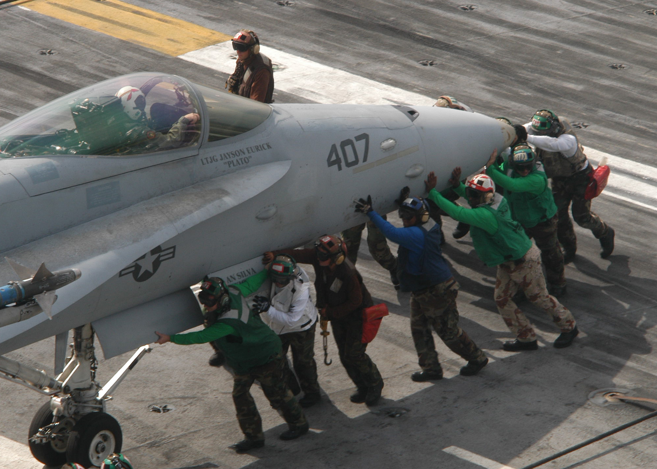 US Navy 030910-N-2838C-502 Flight deck personnel move an F-A-18 Hornet assigned to the 