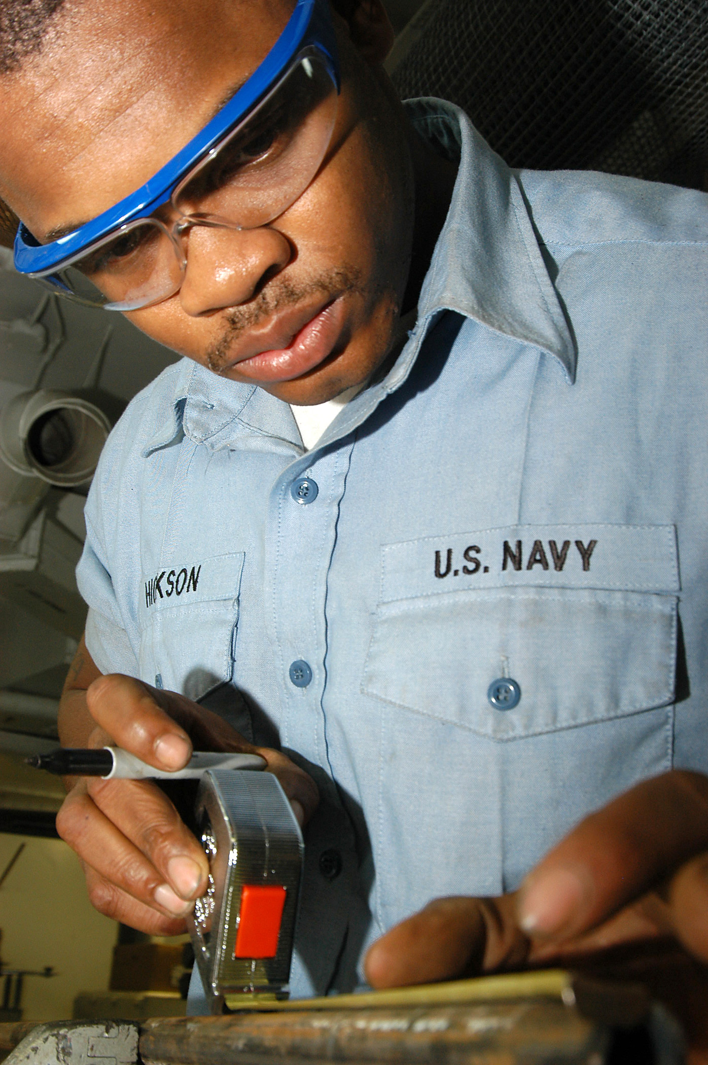 US Navy 031208-N-6278K-001 Hull Technician 3rd Class Thomas Hickson from Marion, S.C., measures a piece of metal in the machine shop aboard USS George Washington (CVN 73)