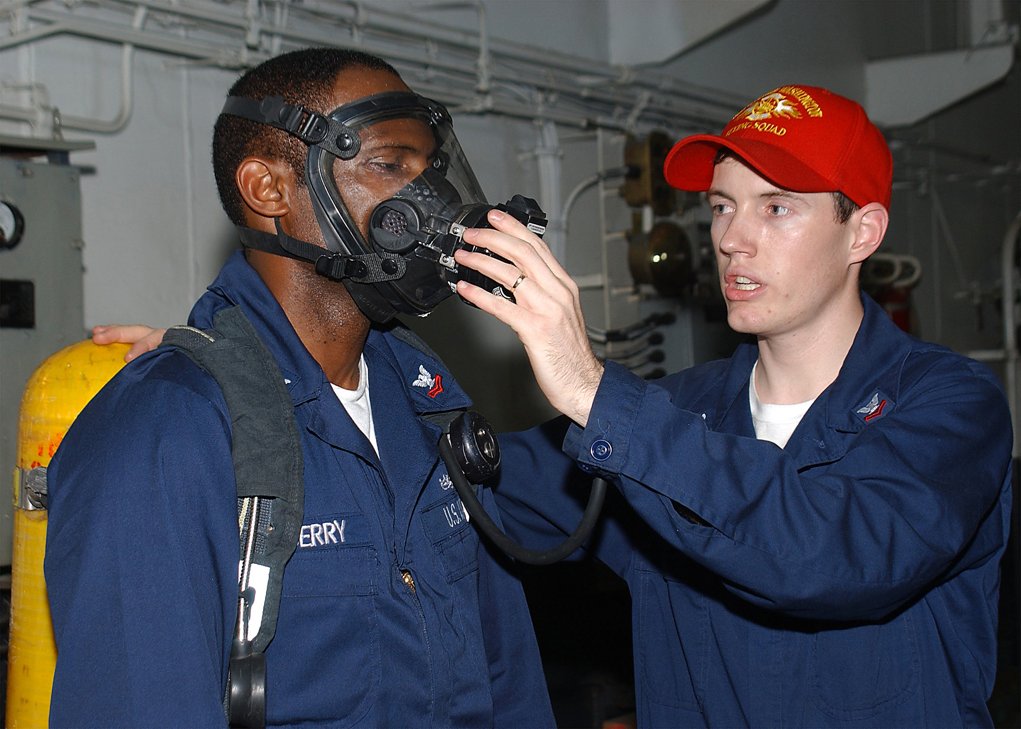 US Navy 040518-N-3992H-007 Damage Controlman 2nd Class Dustin Woolever of Lancaster, Ohio, demonstrates the proper wear and use of the Self Contained Breathing Apparatus (SCBA)