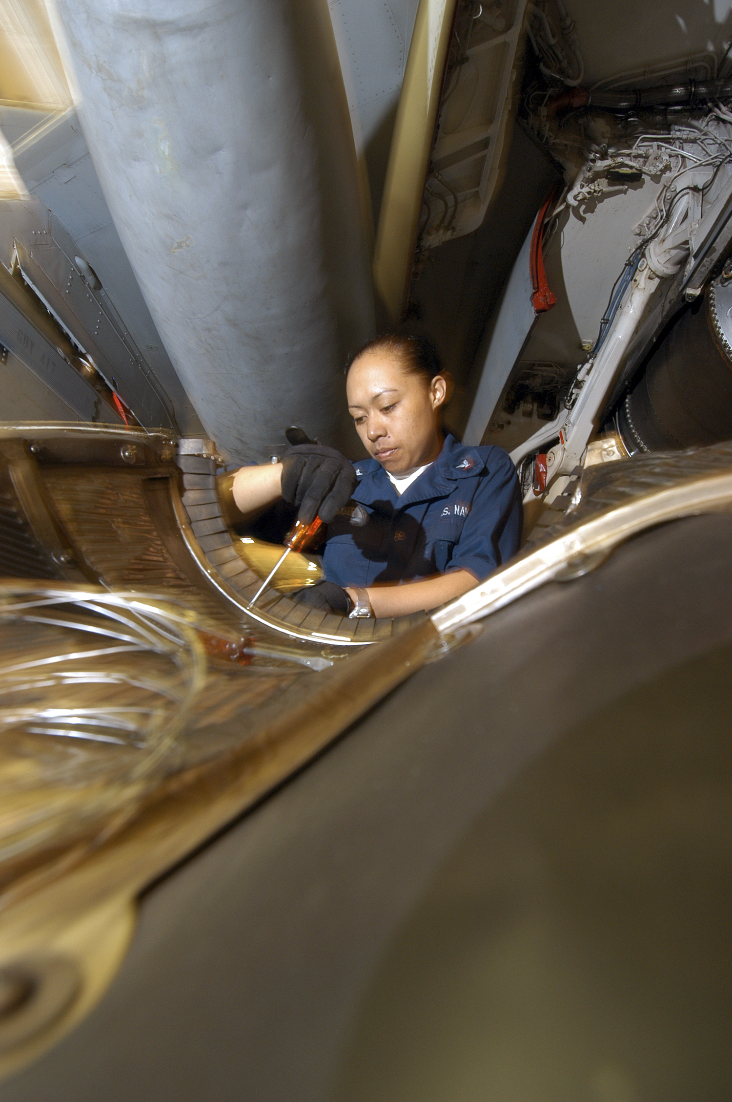 US Navy 040627-N-7748K-019 Aviation Machinist's Mate 3rd Class Irene Sotelo, from Waianae, Hawaii, removes rivets from an EA-6B Prowler engine bay wall