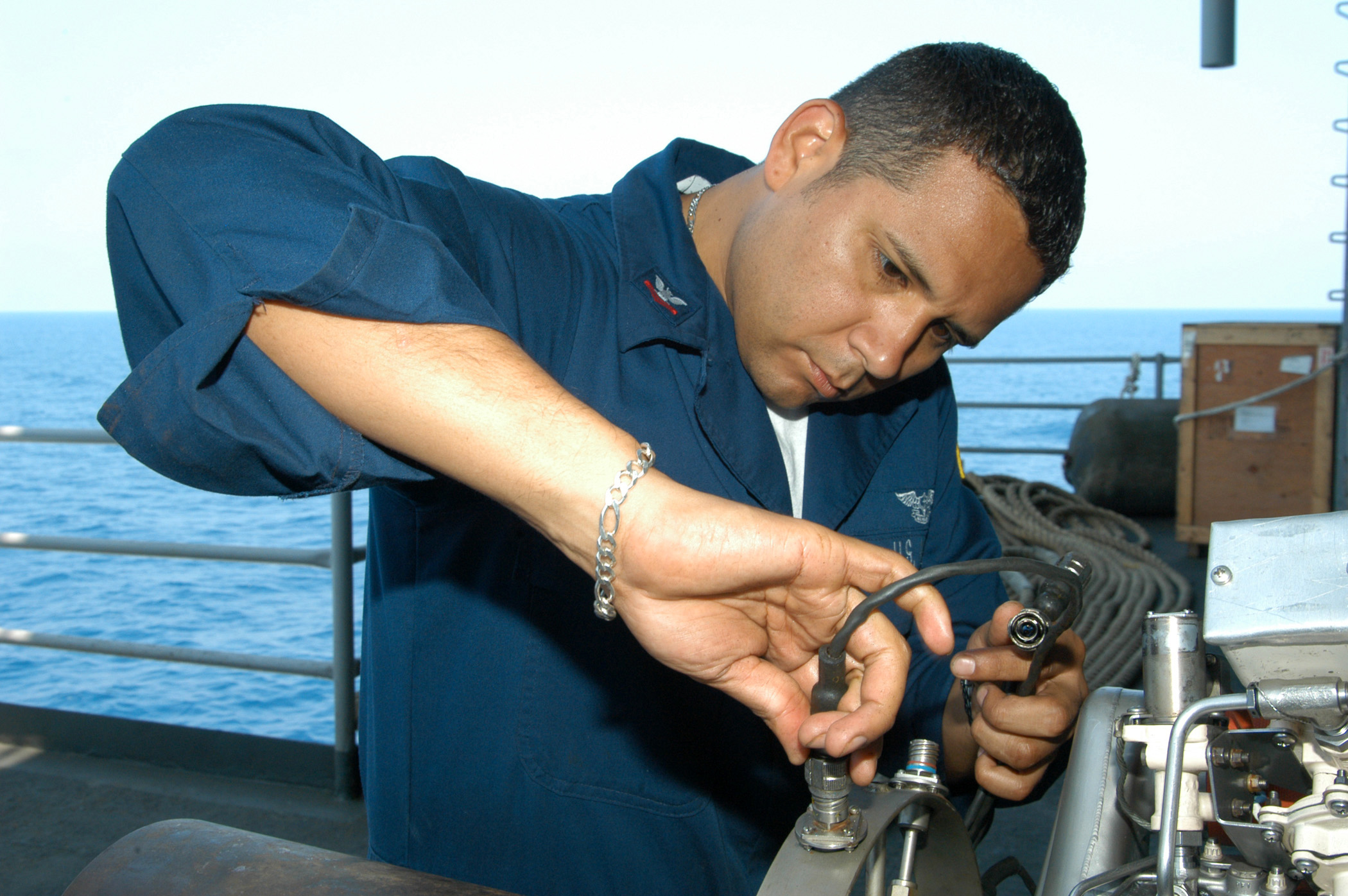 US Navy 040701-N-7695R-002 Aviation Machinist Mate 2nd Class Miguel Ramirez is completing maintenance on the Auxiliary Power Unit (APU) for an F-A-18 