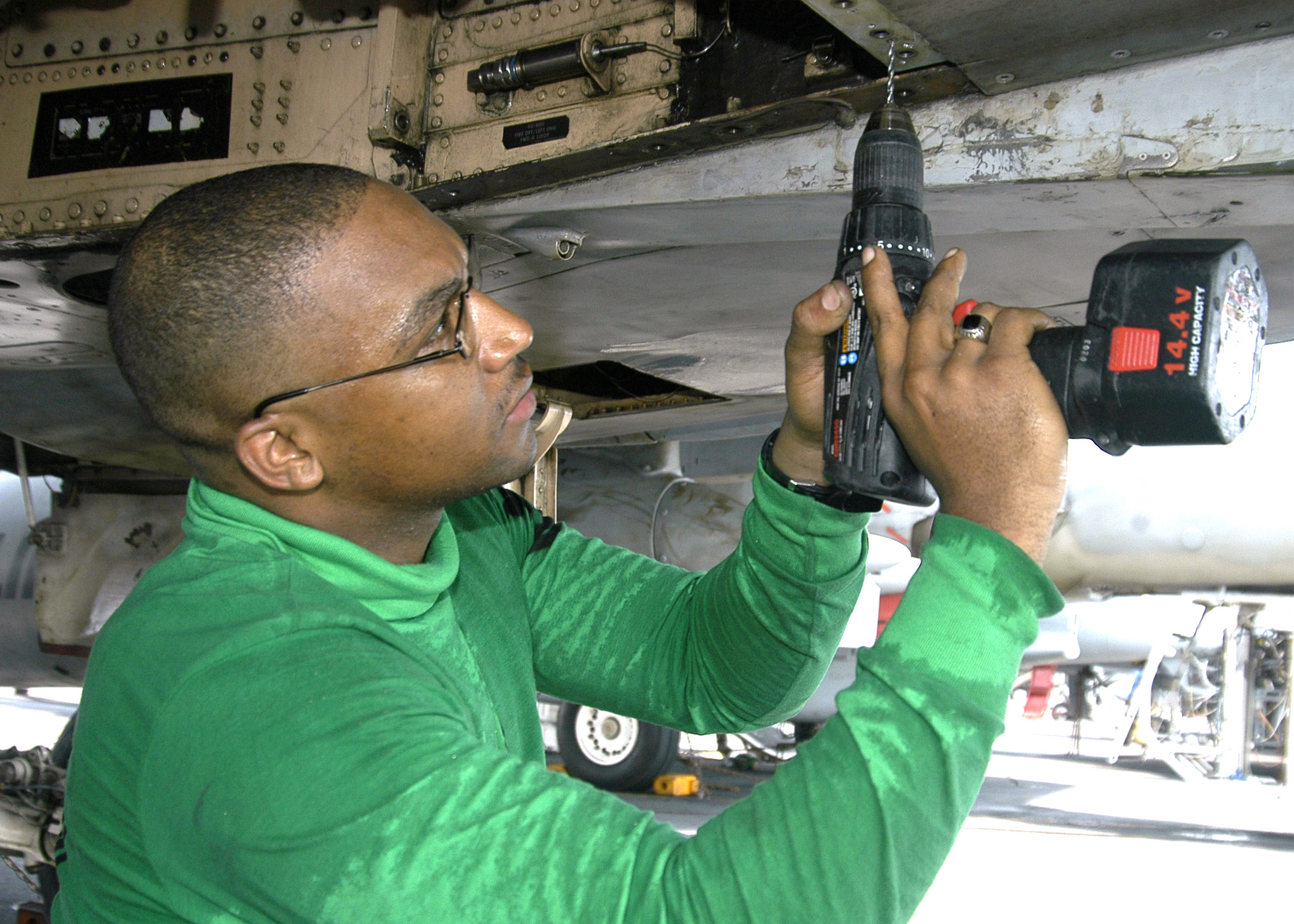 US Navy 040731-N-4565G-002 Aviation Structural Mechanic 2nd Class Kelvin Santos of Bronx, New York replaces rivets on the tail hook hydraulic system of an F-A-18B Hornet 