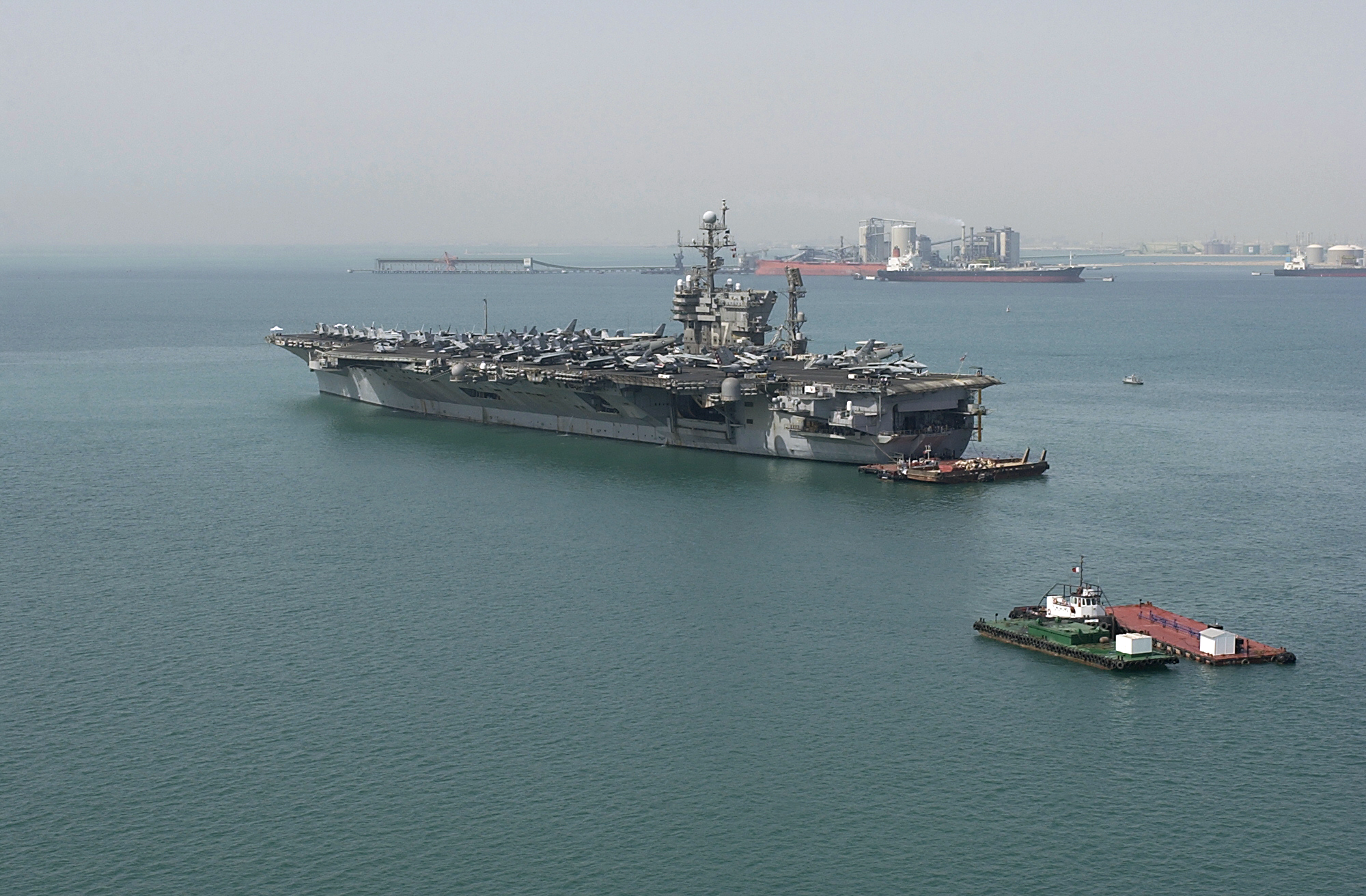 US Navy 040810-N-1348L-002 Tug boats and barges stand by as the aircraft carrier USS John F. Kennedy (CV 67) prepares to get underway after a five-day port visit to Bahrain