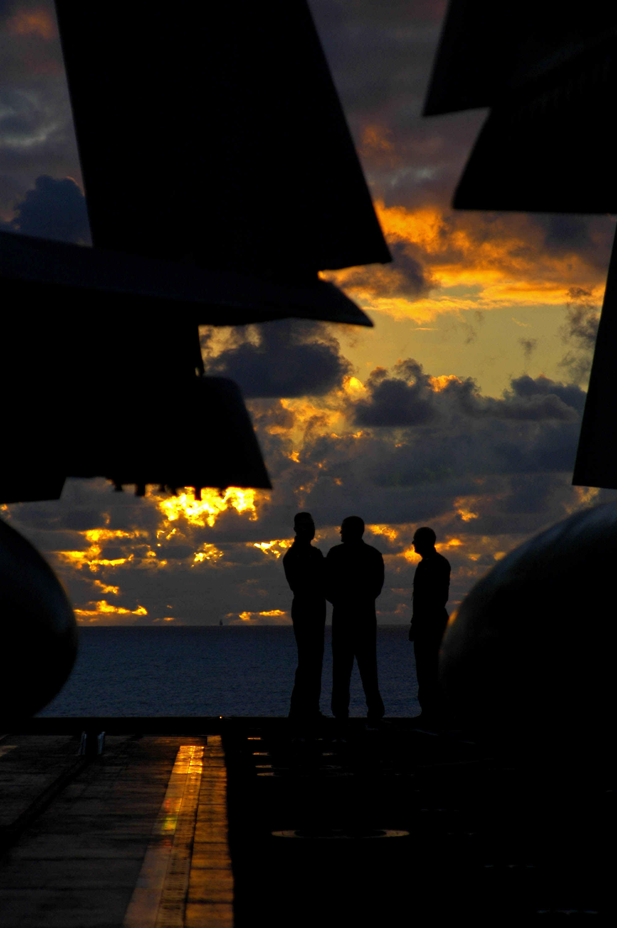 US Navy 041023-N-4166B-041 Pilots aboard the aircraft carrier USS Abraham Lincoln (CVN 72), assemble on the bow of the ship as the sunsets on the western Pacific Ocean