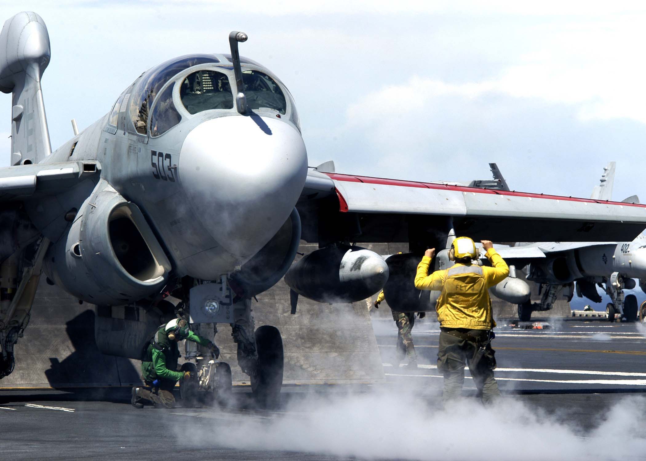 US Navy 041026-N-0499M-096 An Aviation Boatswain's Mate directs an EA-6B Prowler assigned to the Lancers of Electronic Attack Squadron One Three One (VAQ-131) onto a catapult