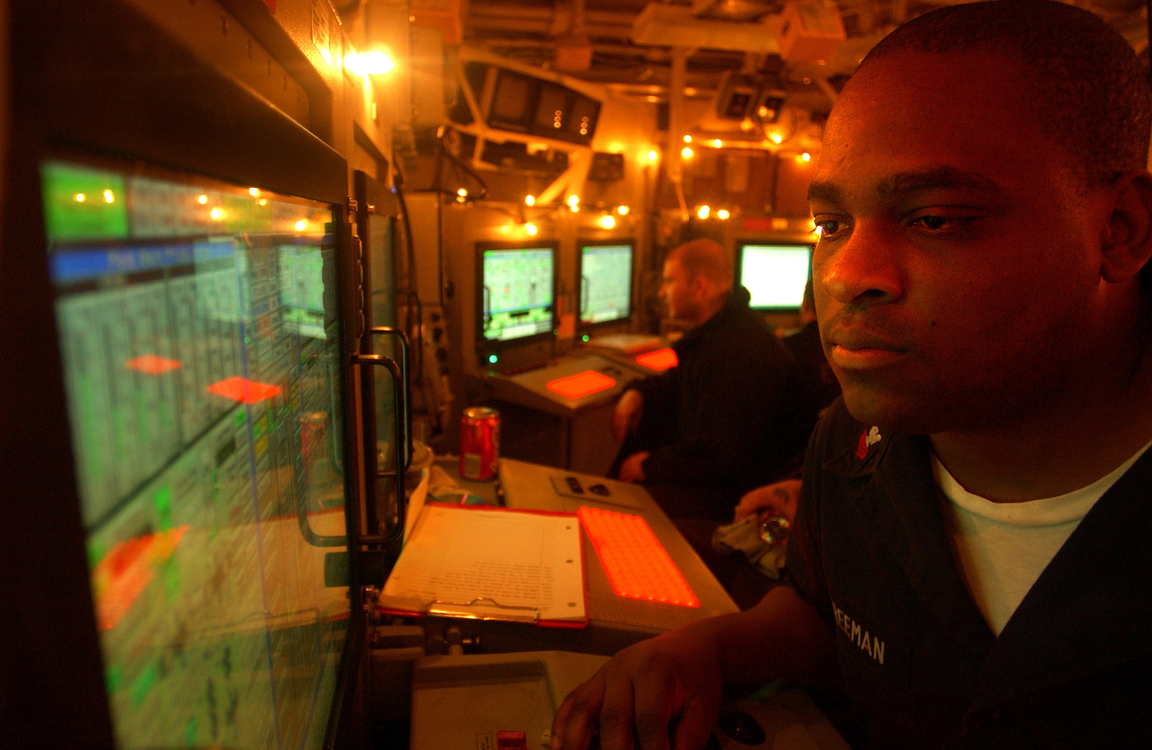 US Navy 041225-N-4953E-017 Gas Turbine Systems Technician 1st Class Ronnie Freeman stands duty as Engineering Officer of the Watch in Damage Control Central