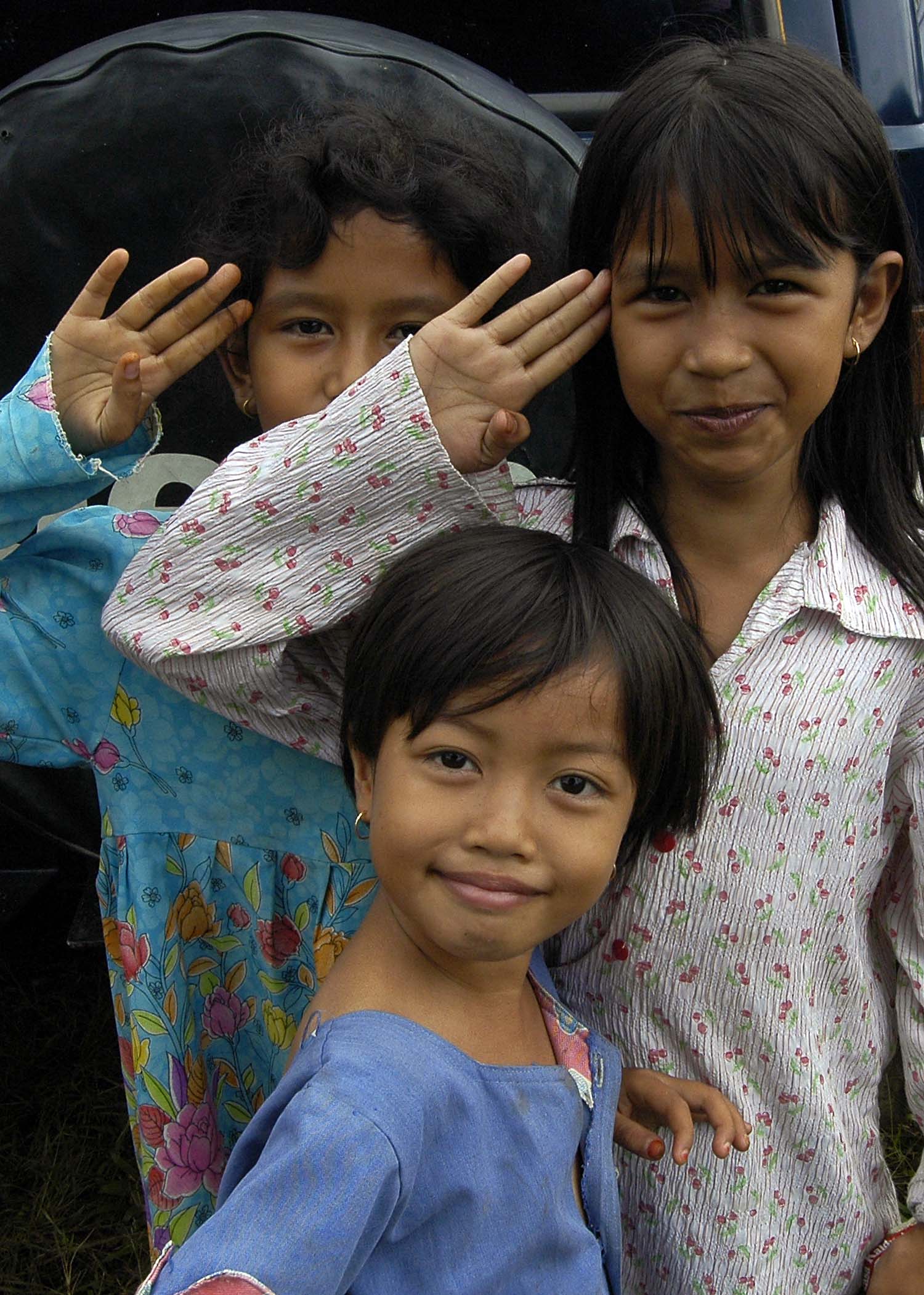 US Navy 050119-N-9951E-067 Young girls salute in their best form for a photo taken at one of the camps located in the town of Alue Bilie, Aceh, for civilians displaced by the Dec. 26 tsunami
