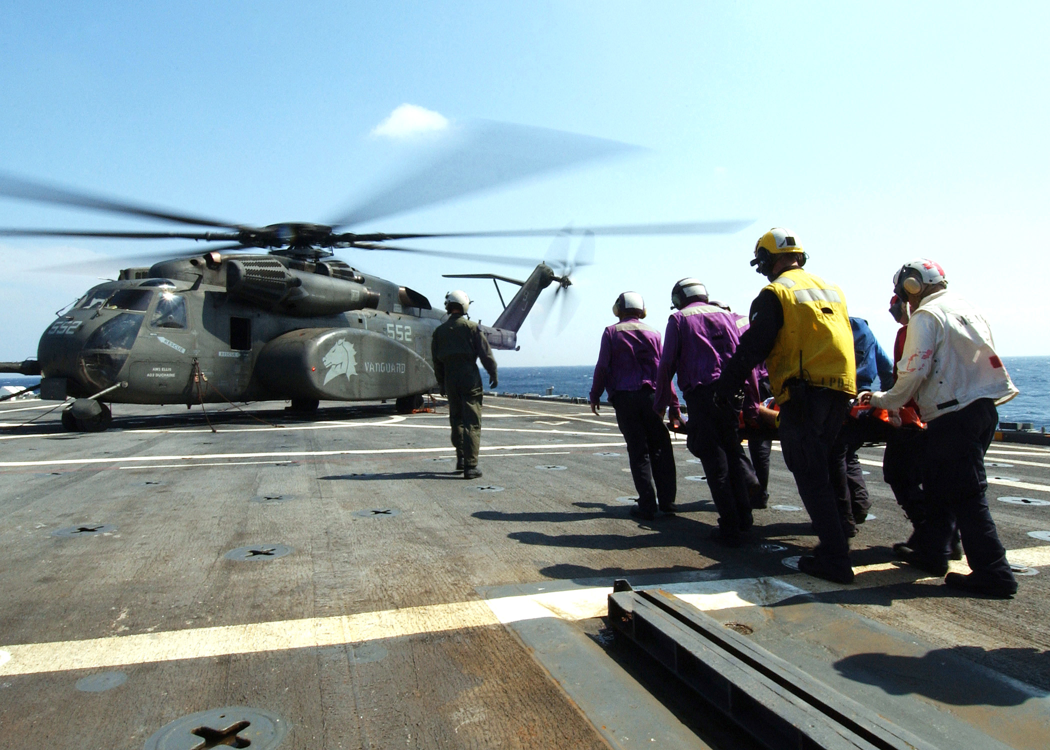 US Navy 050508-N-4374S-003 Stretcher bearers assigned to the amphibious transport dock ship USS Trenton (LPD 14), carry an 83-year old civilian, to an MH-53E Sea Dragon helicopter