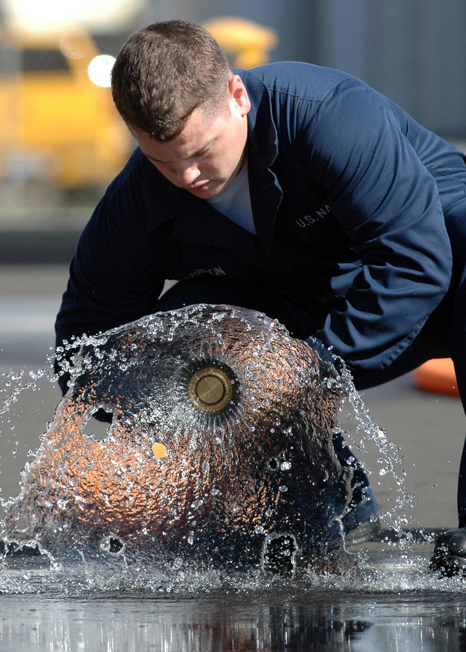 US Navy 051006-N-3019M-003 Damage Controlman Fireman Jason Robinson, assigned to the guided missile destroyer USS Paul Hamilton (DDG 60), opens the nozzle on a fire hose