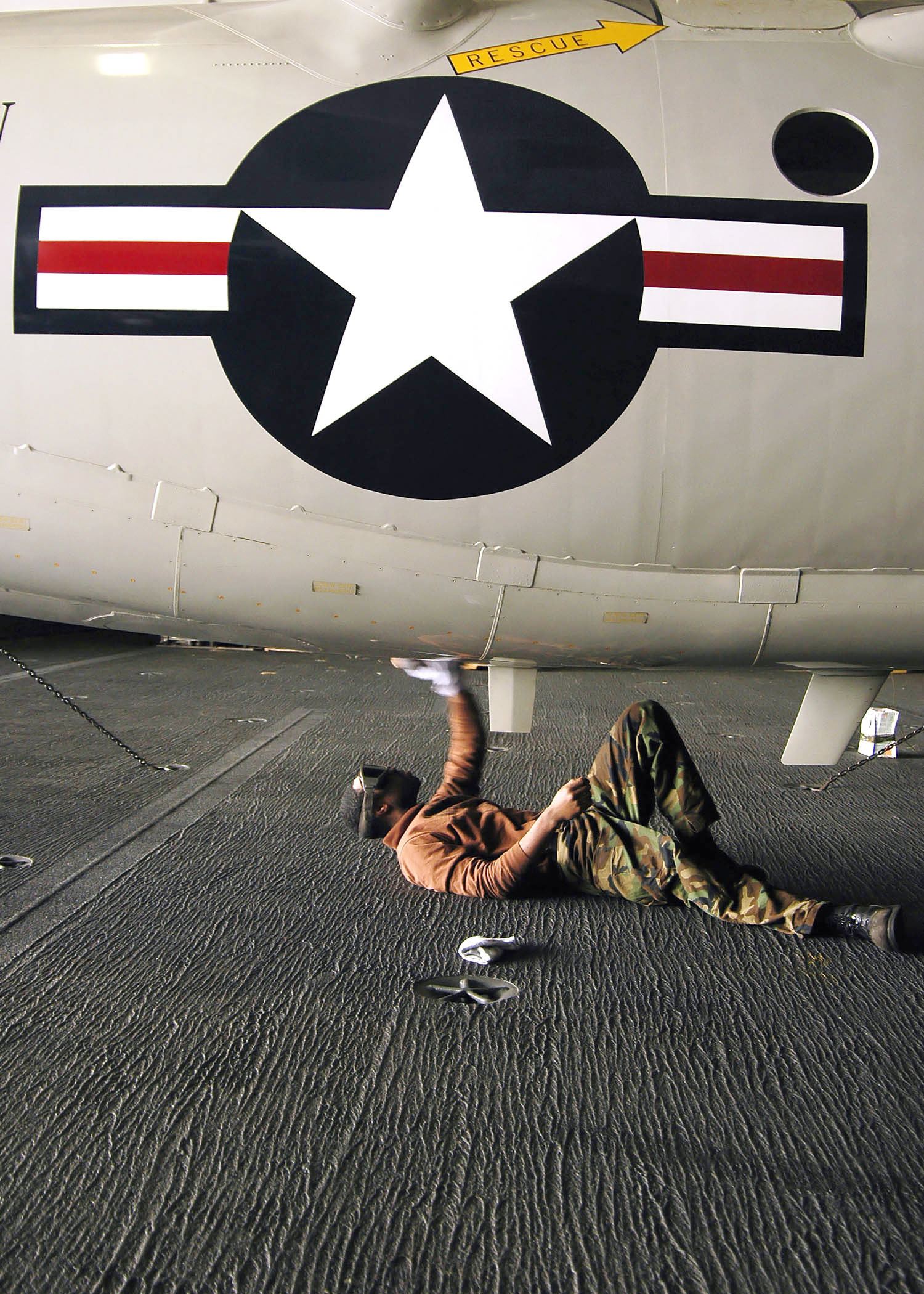 US Navy 060331-N-7981E-044 Airman Elliot Littles cleans the underside of an E-2C Hawkeye assigned to Carrier Airborne Early Warning Squadron One One Six (VAW-116)