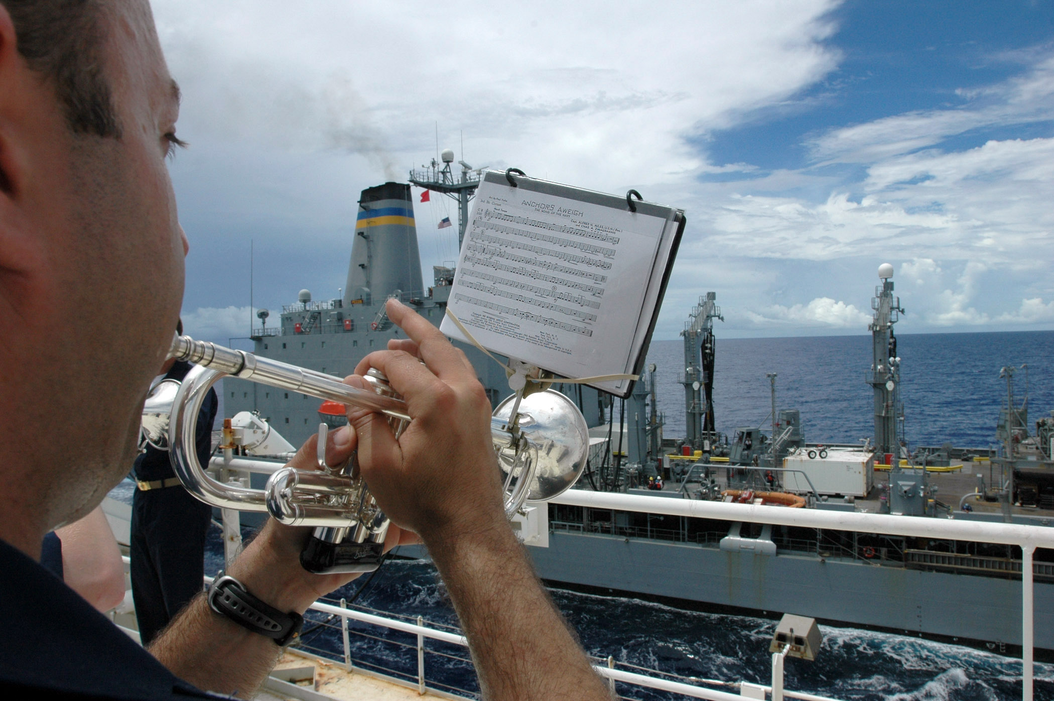 US Navy 060516-N-9076B-024 Musician 1st Class Brian Grondell plays Anchors Away during an underway replenishment between the USNS Pecos and USNS Mercy