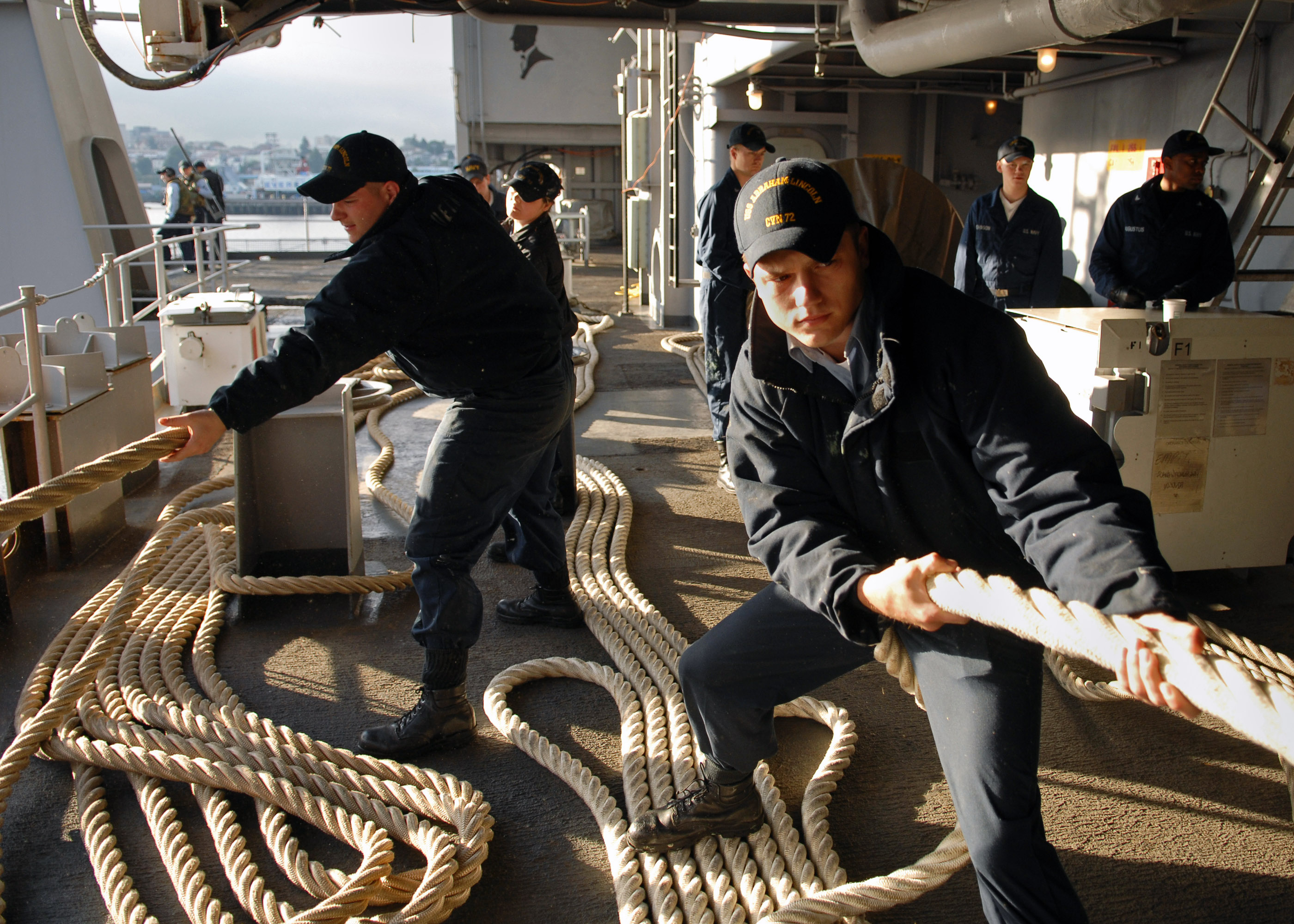 US Navy 070707-N-7981E-028 Seaman Jacob Albon and members of deck department single up lines as Nimitz-class aircraft carrier USS Abraham Lincoln (CVN 72) gets underway from her home port