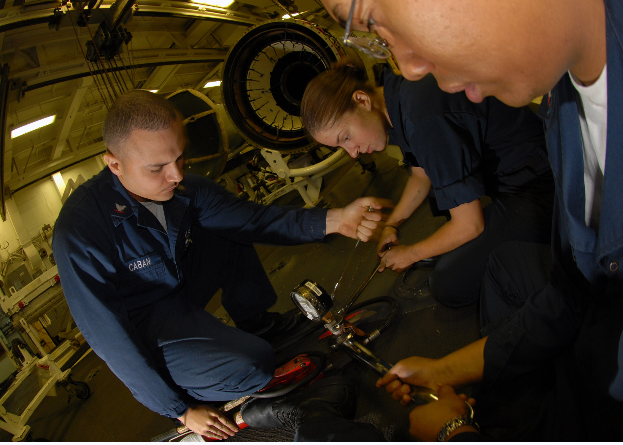 US Navy 070808-N-2910W-001 Sailors use wrenches to calibrate pressure valve to the turbine from a hydraulic pump in the Jet Shop aboard Nimitz-class aircraft carrier USS Abraham Lincoln (CVN 72)