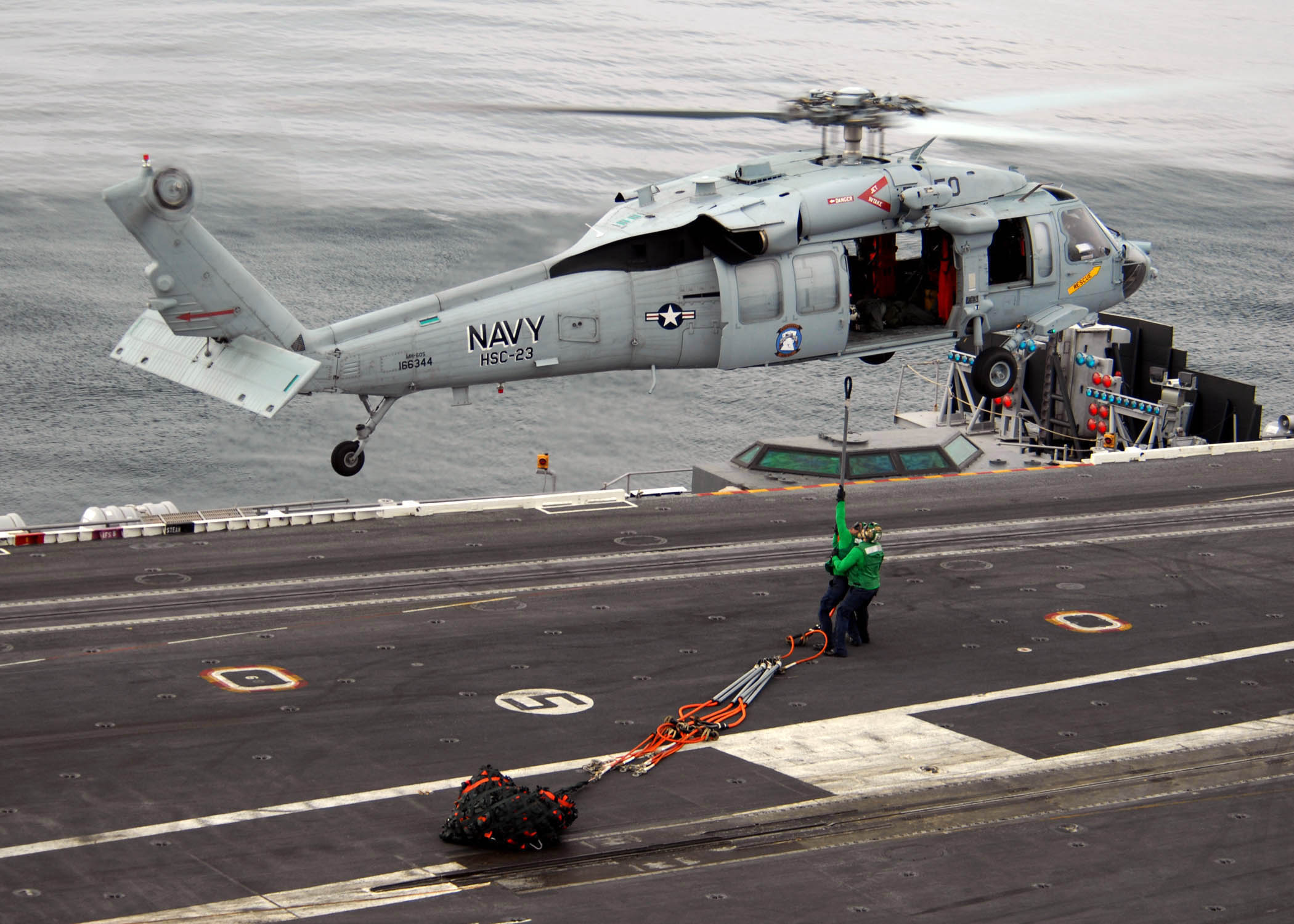 US Navy 071103-N-9898L-203 Sailors attach a hoisting cable to an MH-60S Seahawk, assigned to the 