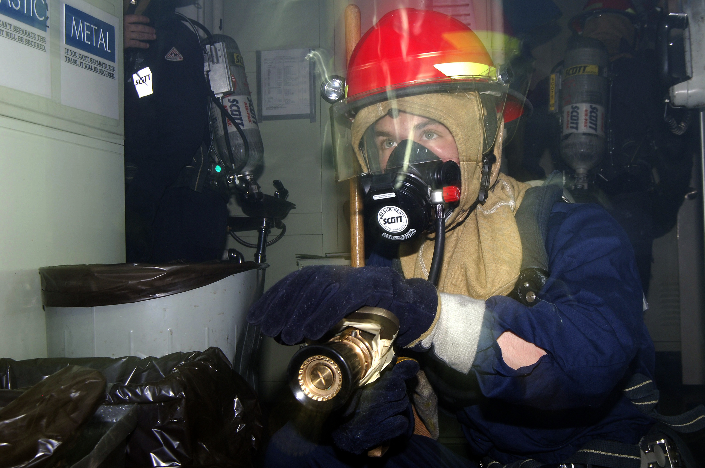 US Navy 080219-N-2420K-044 Damage Controlman 3rd Class Anthony White stands watch for a re-flash during a damage control drill aboard the guided-missile frigate USS Ingraham (FFG 61)