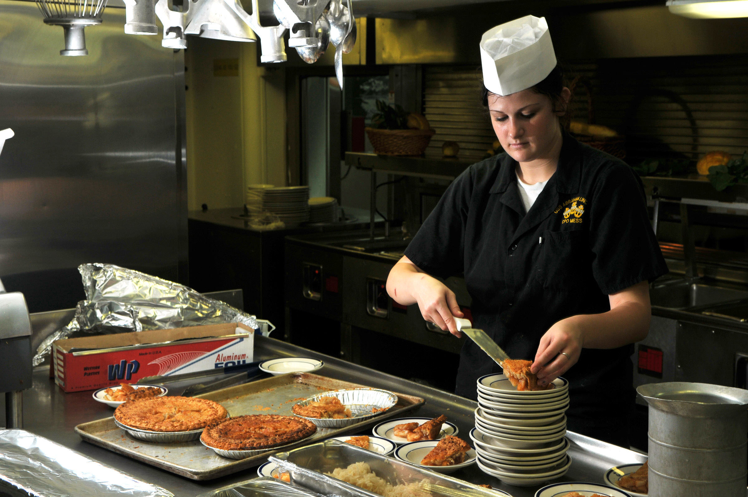 US Navy 080731-N-7981E-116 Operations Specialist Seaman Apprentice Amy Caccamise prepares pie servings