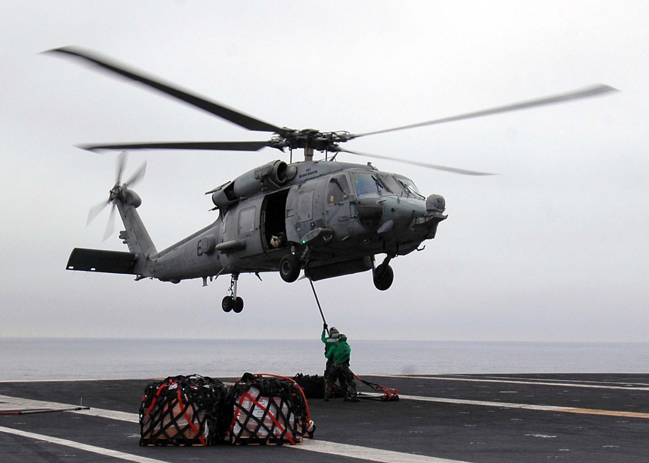 US Navy 080903-N-1161Z-092 Sailors aboard USS George Washington (CVN 73) attach a cargo pendant to an HH-60H Sea Hawk helicopter during a vertical replenishment at sea with USNS Henry J. Kaiser (T-AO 187)