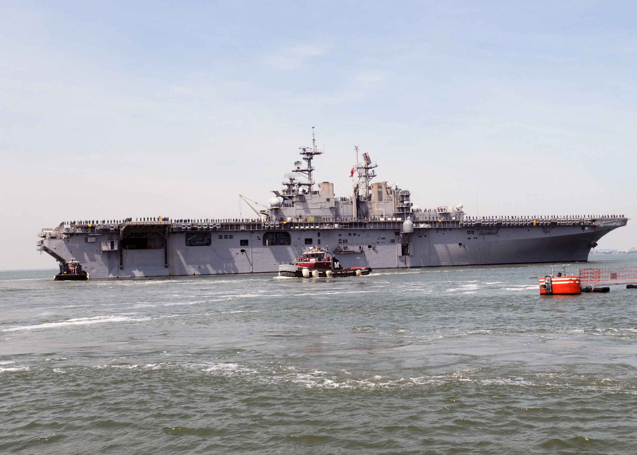 US Navy 090513-N-9985W-059 Tugs assists the multi-purpose amphibious assault ship USS Bataan (LHD 5) departs Naval Station Norfolk on a regularly scheduled deployment