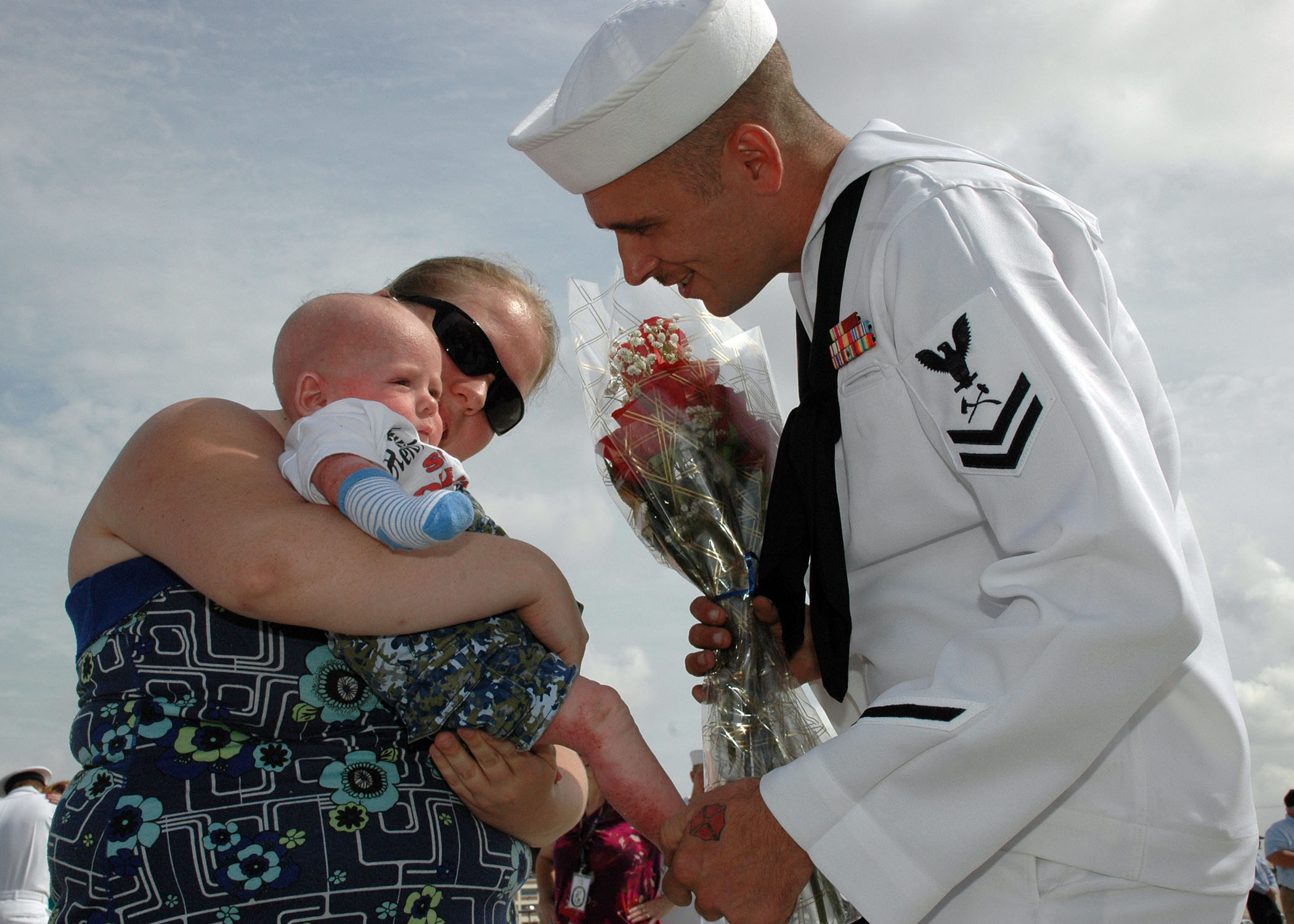 US Navy 090828-N-5292M-521 Damage Controlman 2nd Class Jeff McClure, assigned to the guided-missile destroyer USS Laboon (DDG 58), greets his 5-month-old son for the first time at Naval Station Norfolk, Va