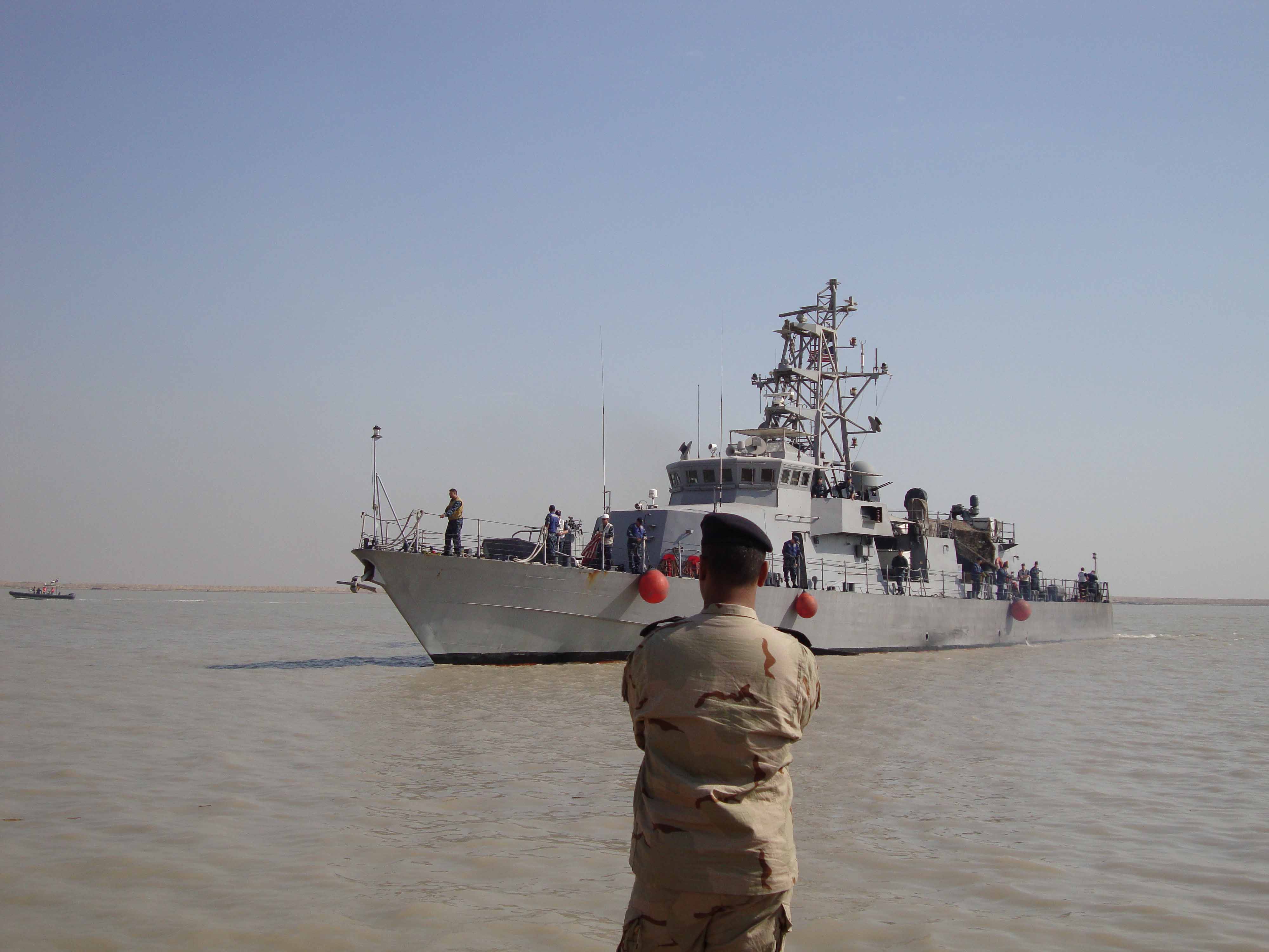 US Navy 091114-N-0000X-001 A member of the Iraqi Defense Forces watches as the coastal patrol boat USS Firebolt (PC 10) approaches Umm Qasr, Iraq