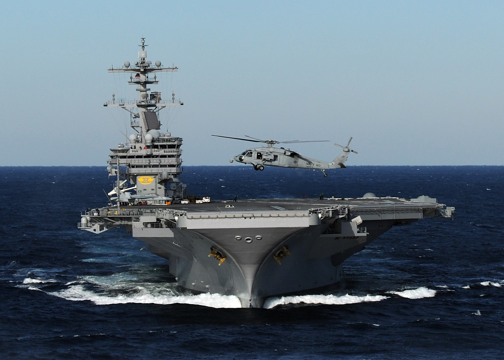 US Navy 100227-N-4408B-163 An MH-60S Sea Hawk helicopter hovers above the bow of USS George H.W. Bush (CVN 77) during flight operations