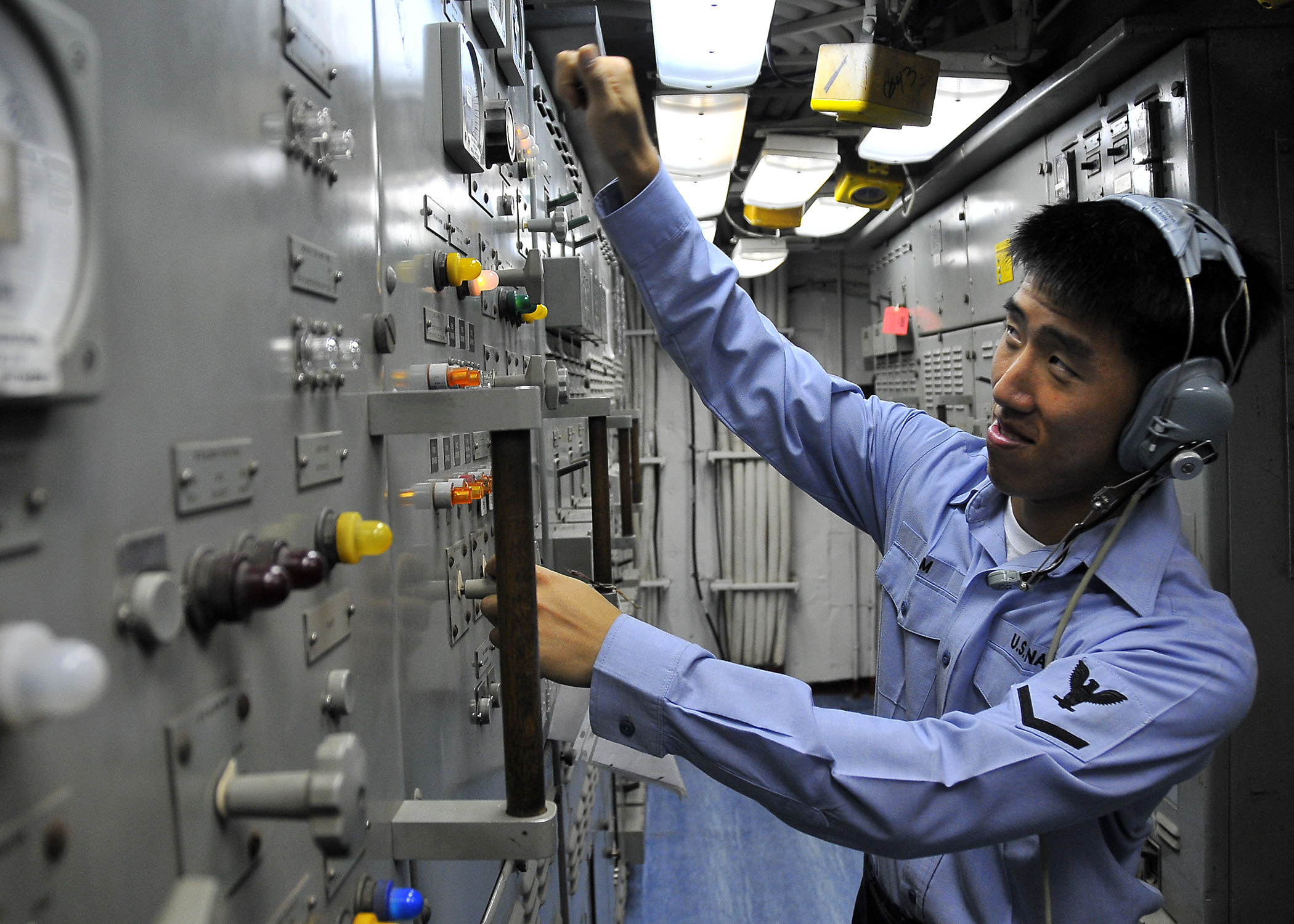 US Navy 100409-N-4774B-620 Electrician's Mate 3rd Class Ju Kim, from Alexandria, Virginia, operates controls in Main Engine Room Two aboard the guided-missile cruiser USS Bunker Hill (CG 52)