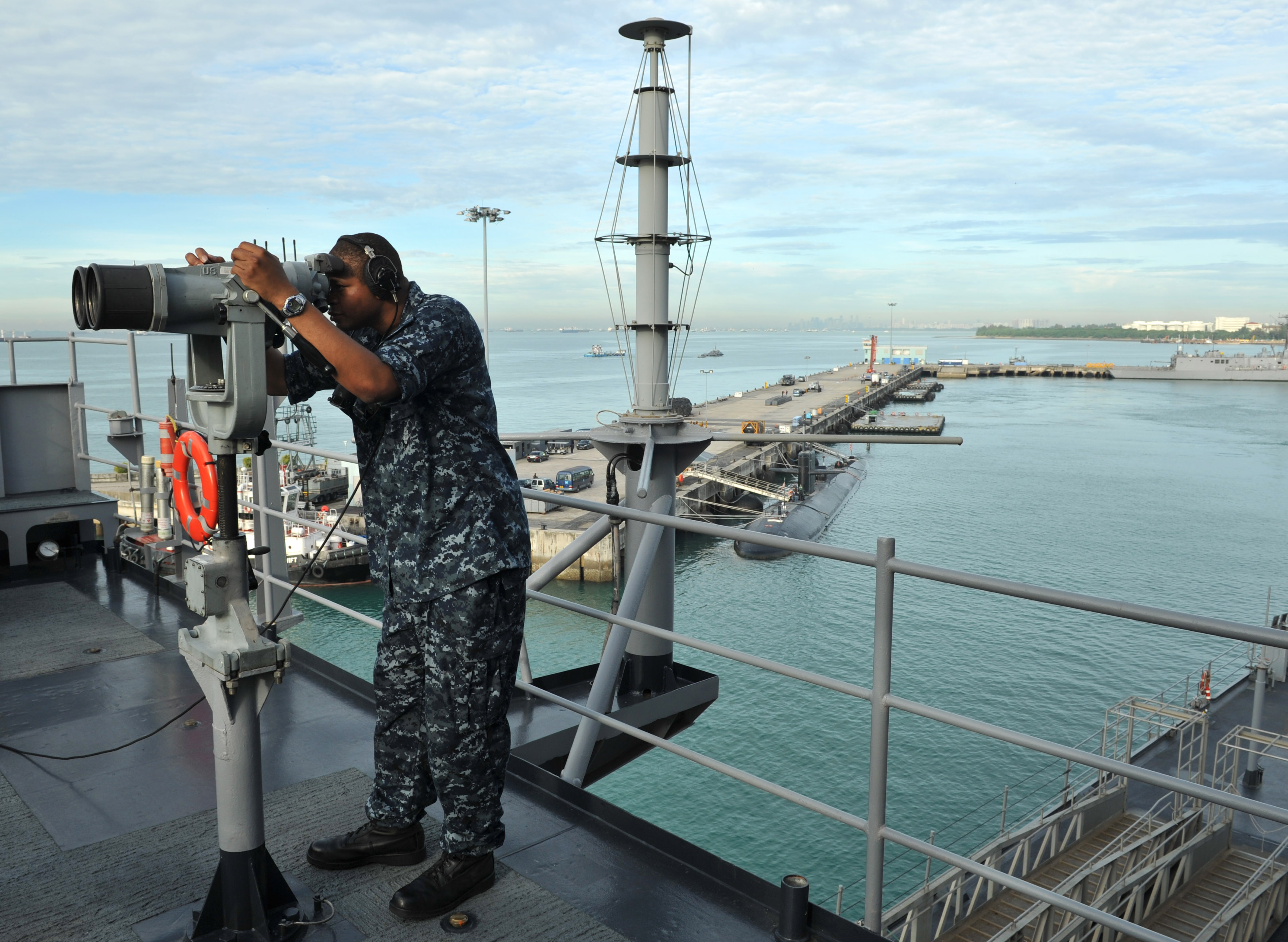 US Navy 110312-N-0864H-280 Operations Specialist 3rd Class Anthony Wilson looks through the 