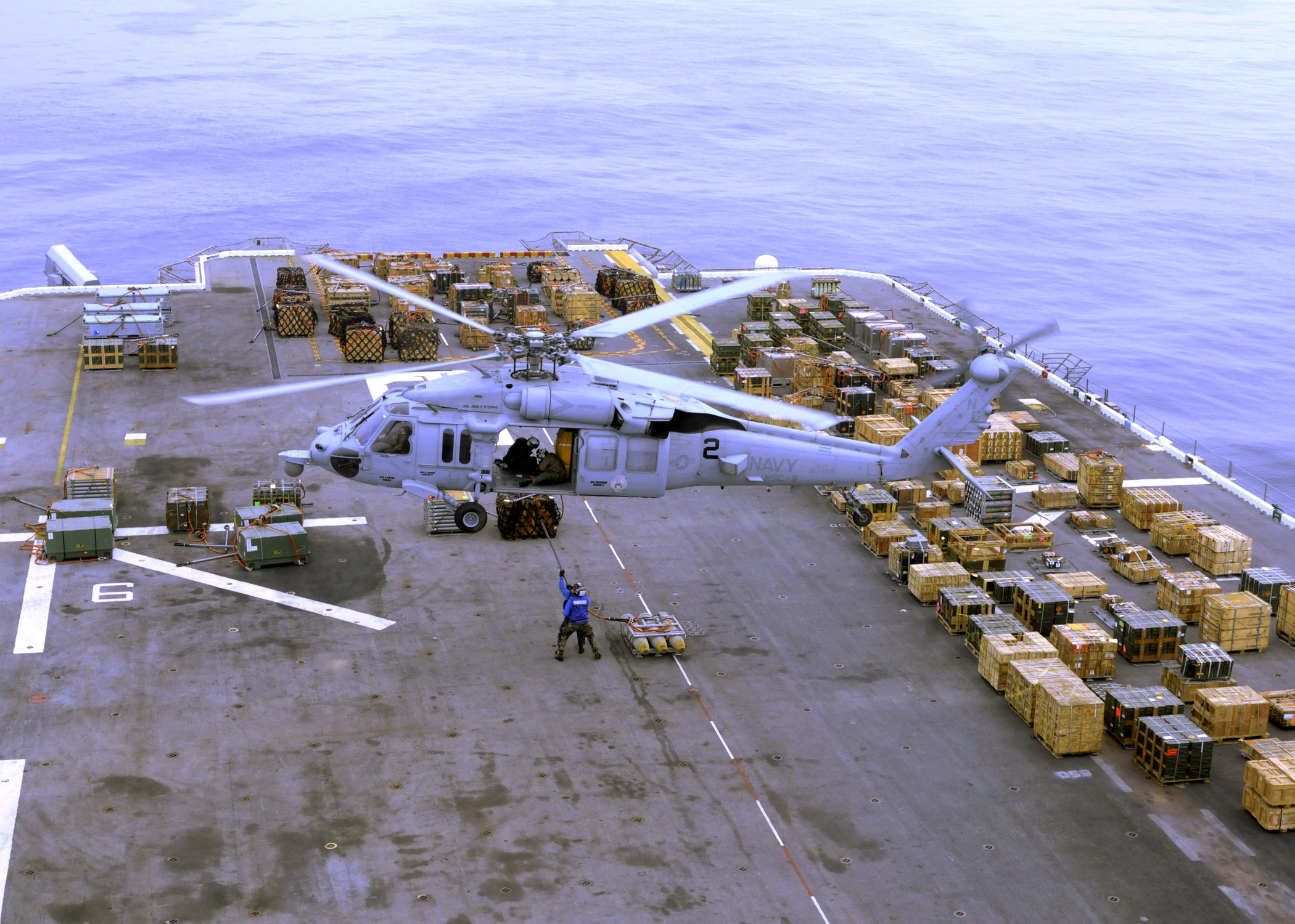 US Navy 110316-N-0126S-082 Sailors aboard the amphibious assault ship USS Peleliu (LHA 5) hook a pallet of ammunition to an MH-60S Sea Hawk helicop