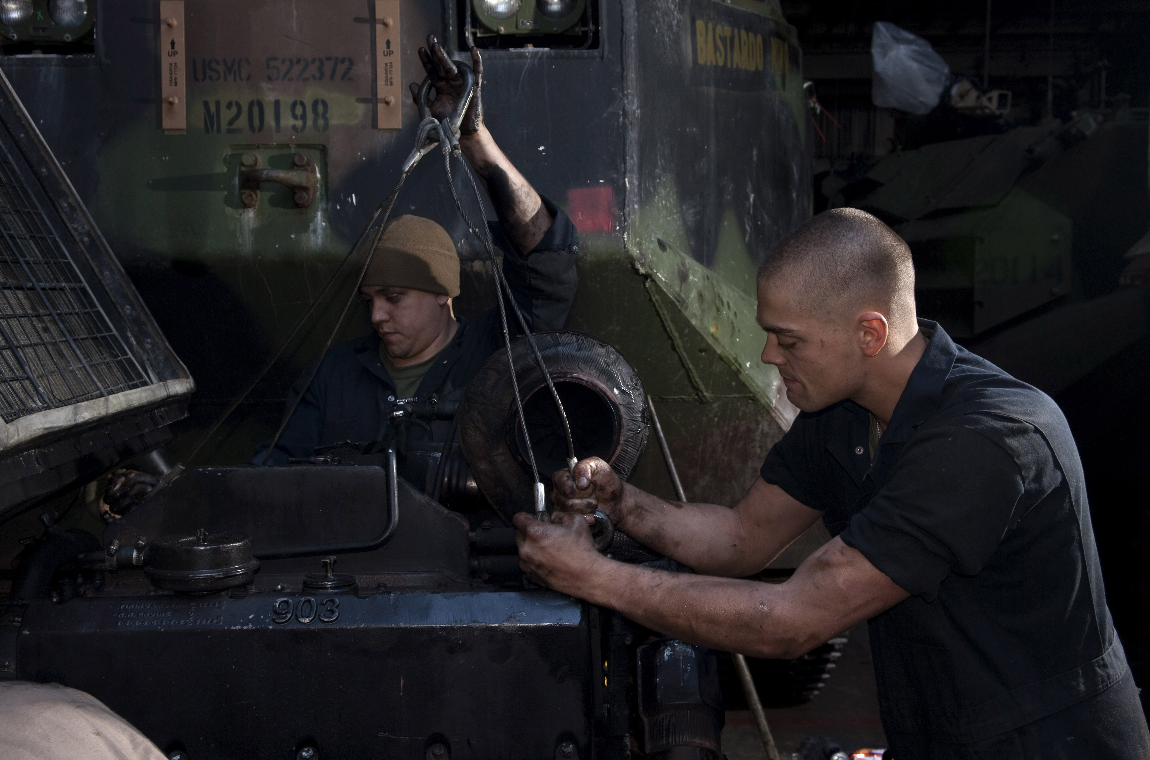 US Navy 110406-N-QP268-162 Lance Cpl. Taylor Fenderson, right, and Lance Cpl. Chris Arbino hook lifting straps to a amphibious assault vehicle (AAV