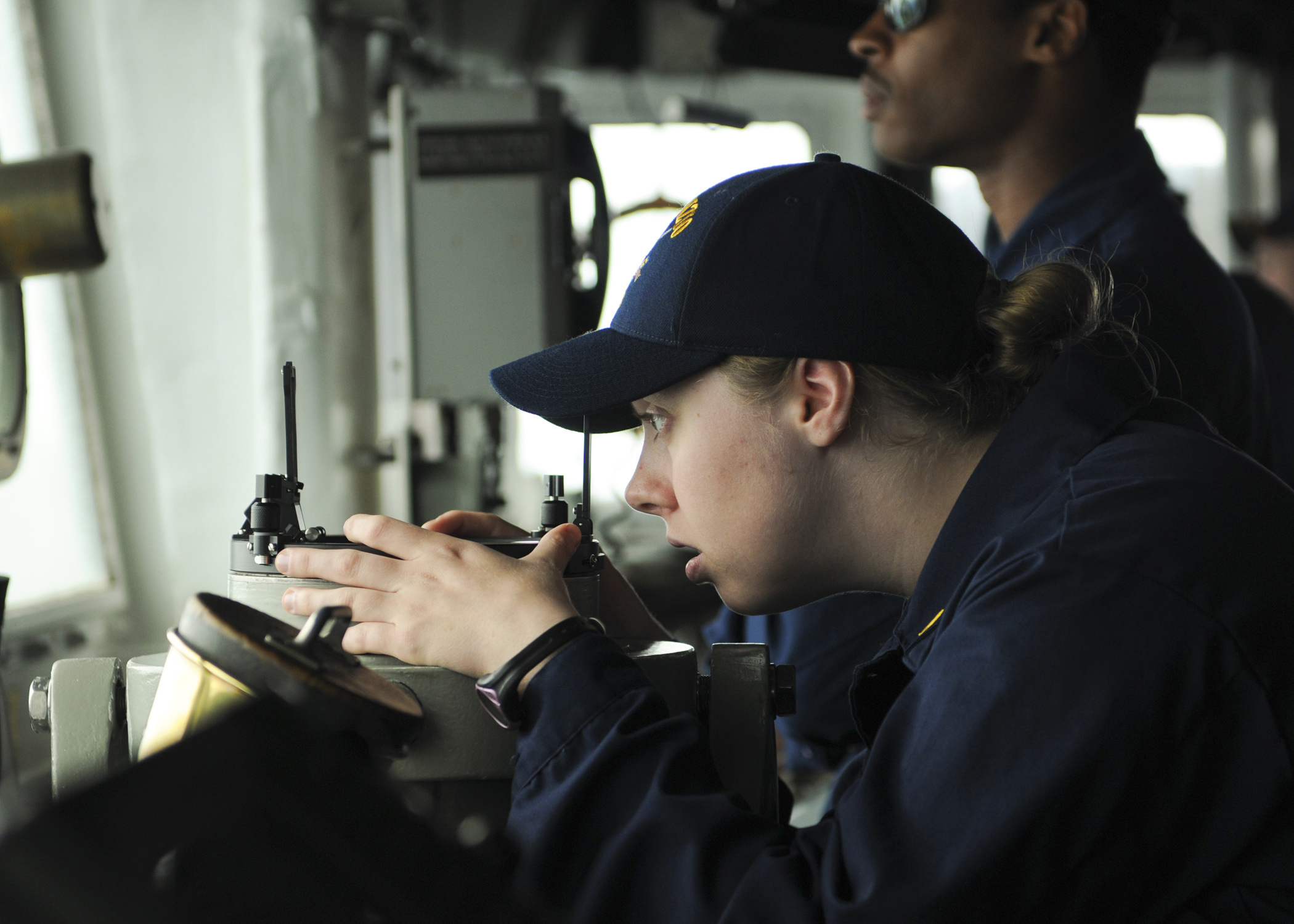US Navy 110515-N-YM590-102 Ensign Meredith C. Manuel peers through a telescopic alidade on the bridge aboard the guided-missile cruiser USS Anzio (