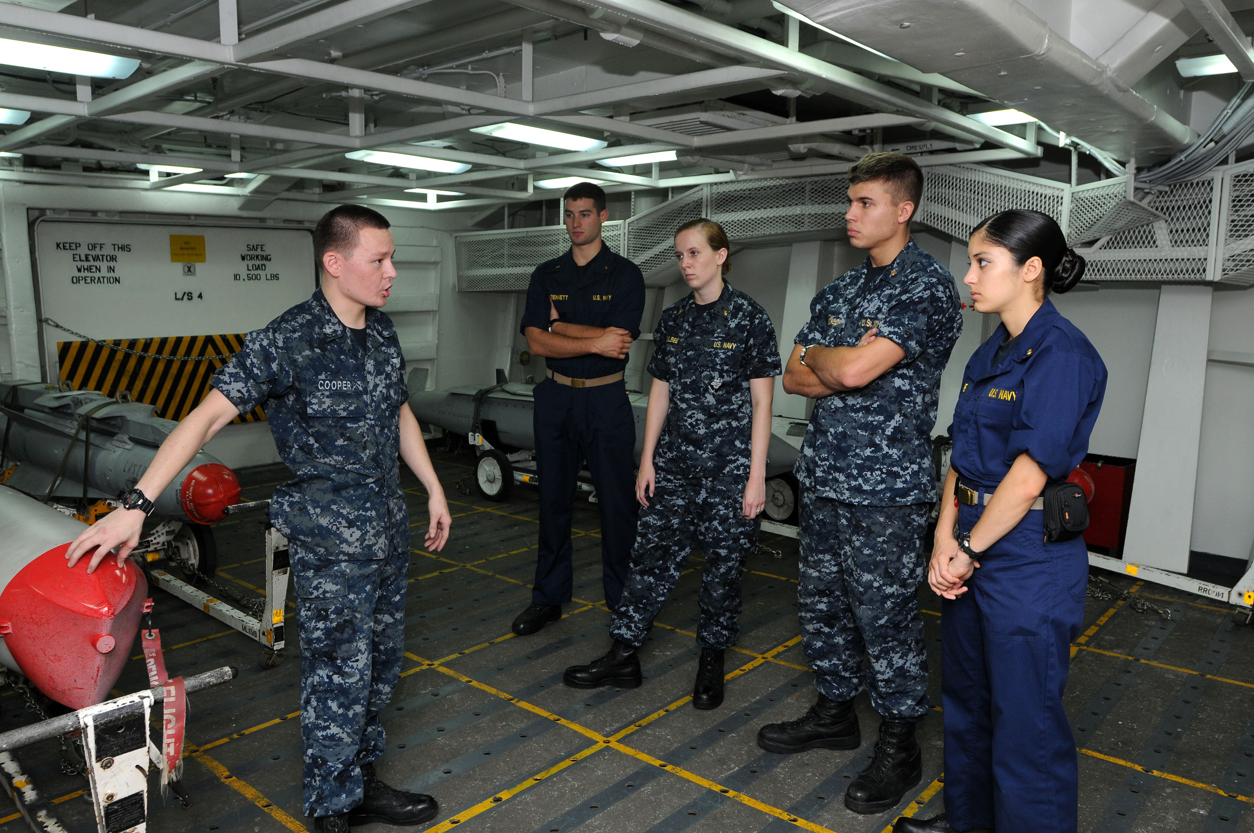 US Navy 110705-N-NB544-031 Aviation Ordnanceman 2nd Class Daniel Cooper, left, explains the different types of ordnance to midshipmen aboard aircra
