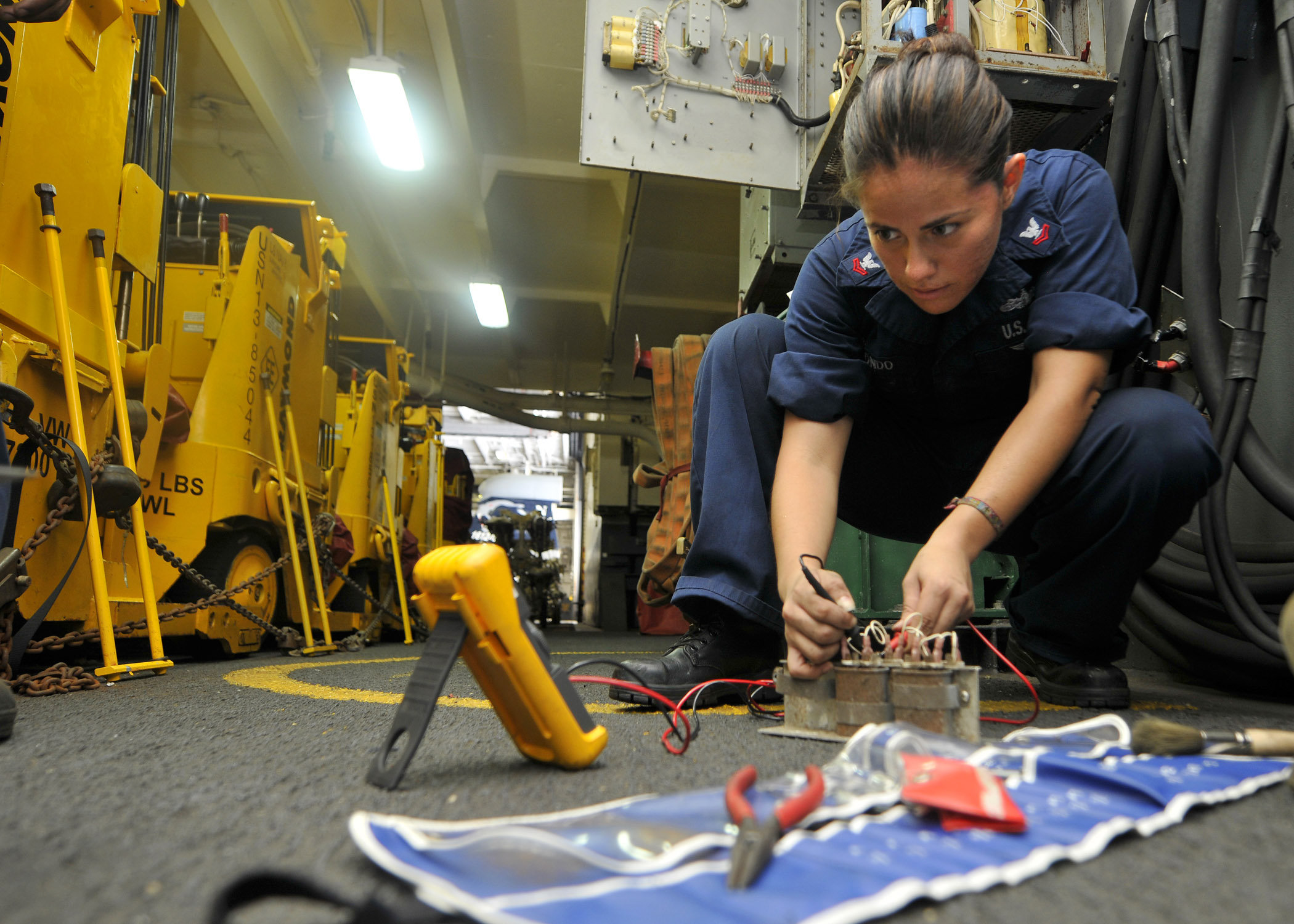 US Navy 110723-N-EE987-125 Electrician's Mate 2nd Class Maria Arreedondo, from Houston, uses a flow divider while fixing a forklift battery chargin