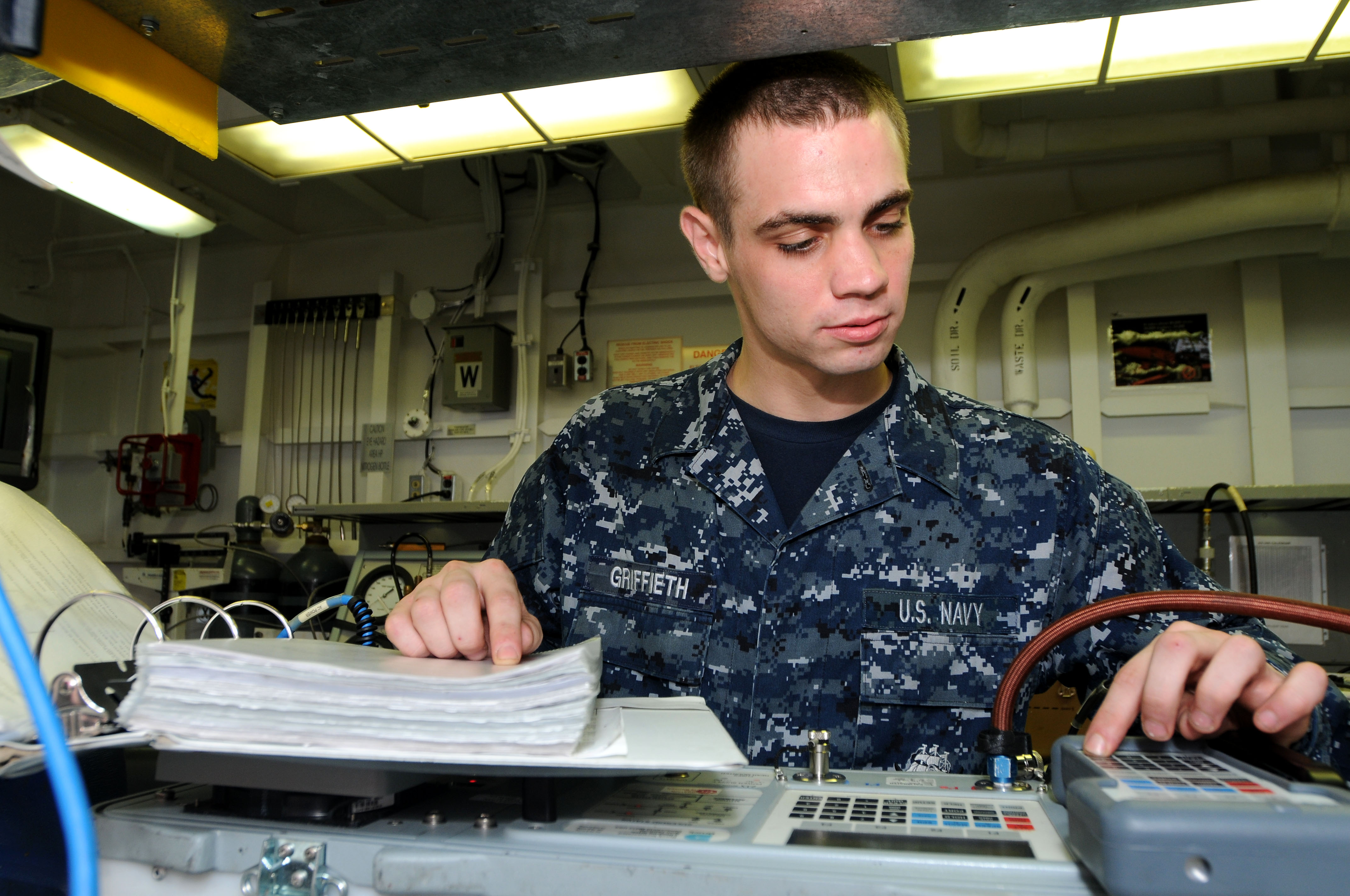US Navy 110727-N-NB544-014 Aviation Electronics Technician Airman Mark Griffieth calibrates an air data test set calibrator aboard USS Ronald Reaga