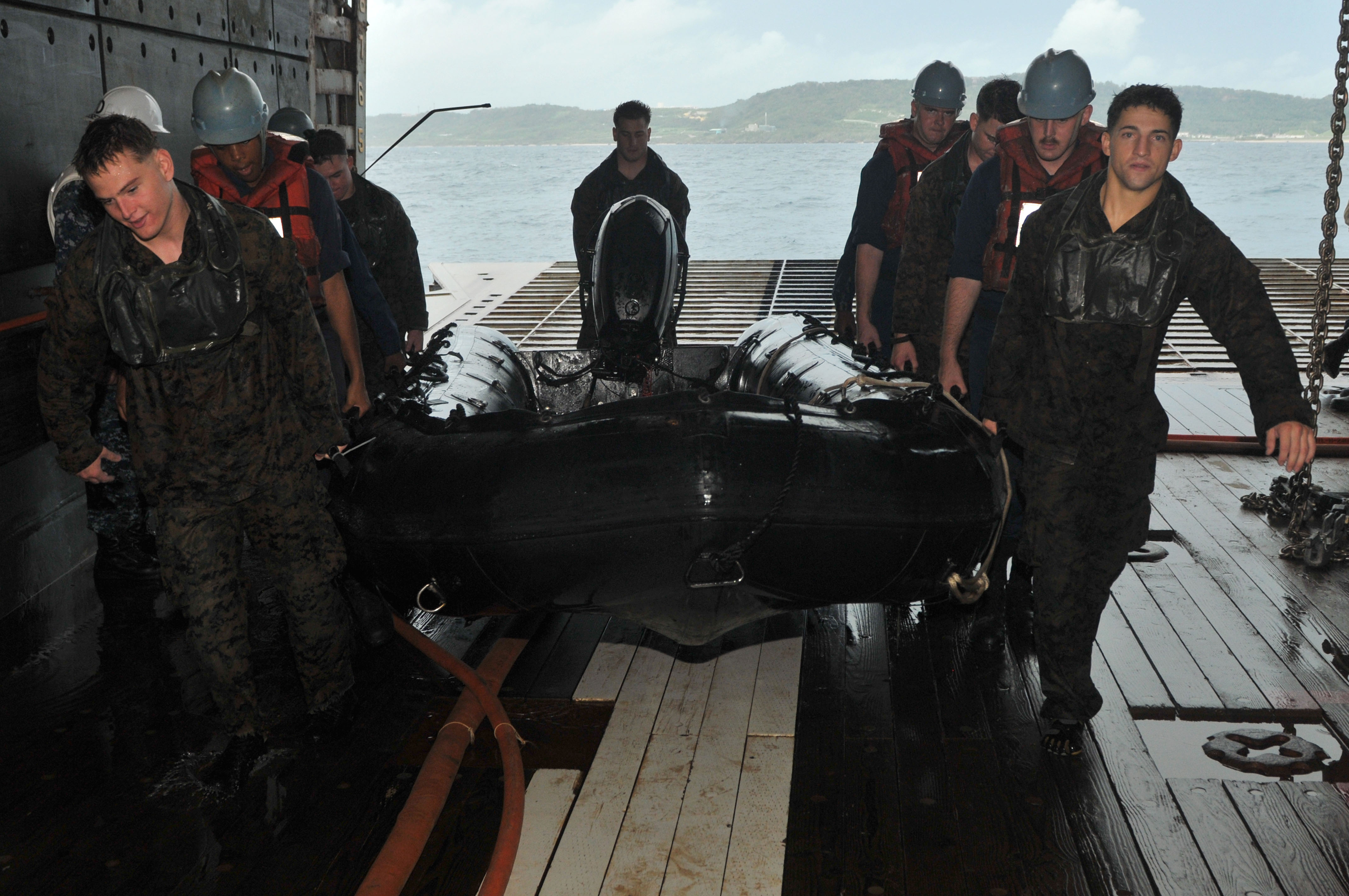 US Navy 111004-N-KM175-100 Sailors and Marines recover a combat rubber raiding craft in the well deck of the forward-deployed amphibious assault sh