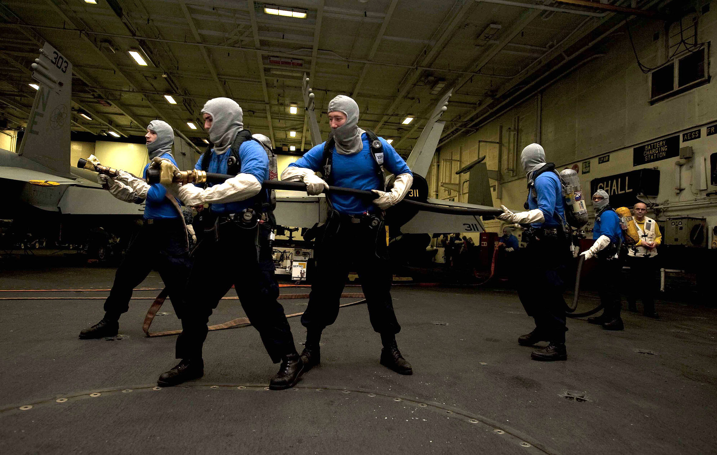 US Navy 111217-N-JN664-024 Sailors participate in an aircraft fire drill in the hangar bay of the Nimitz-class aircraft carrier USS Abraham Lincoln