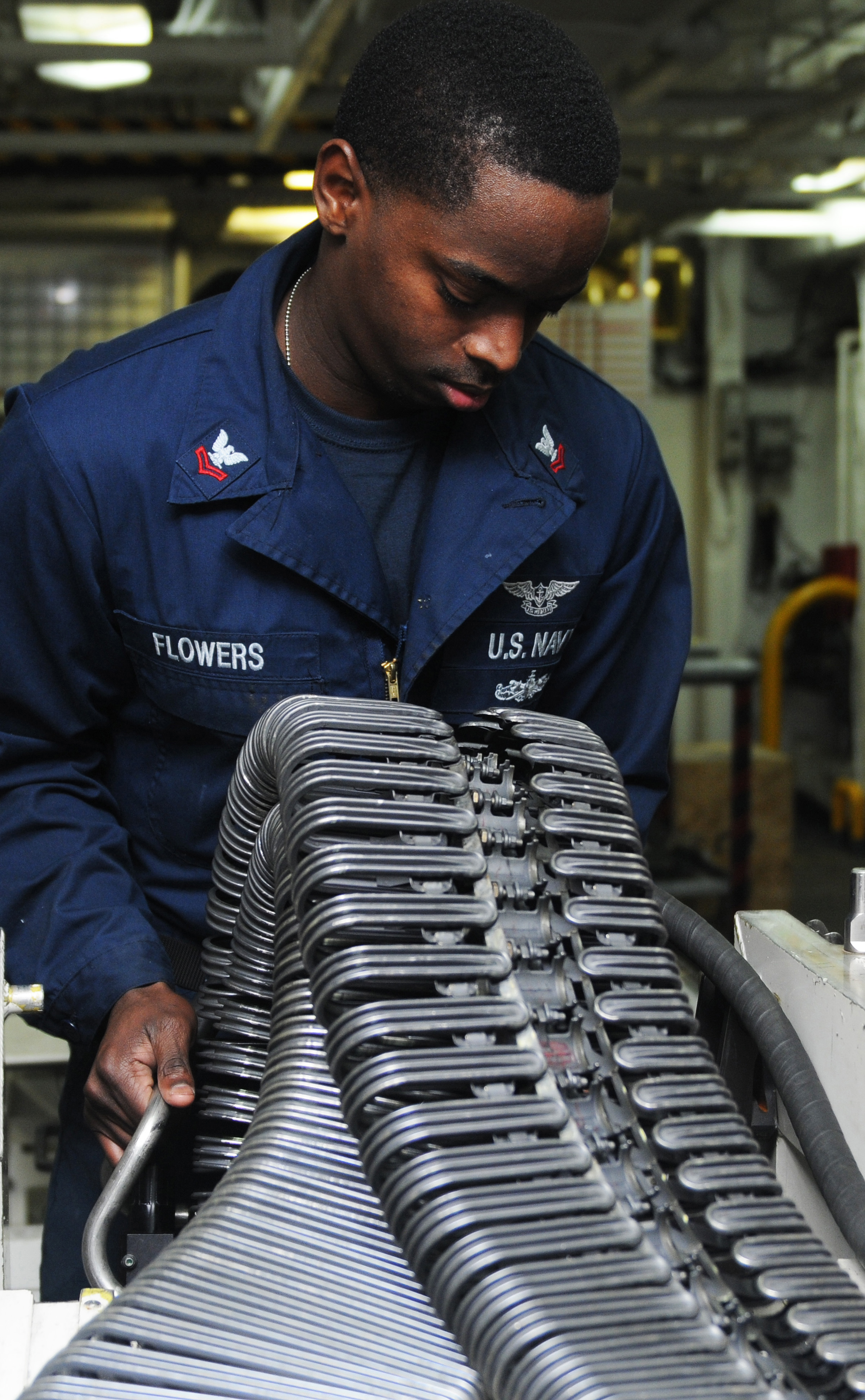 US Navy 120127-N-KQ416-003 Aviation Ordnanceman 2nd Class Timothy A. Flowers verifies a linkless ammunition loading system (LALS) for certification