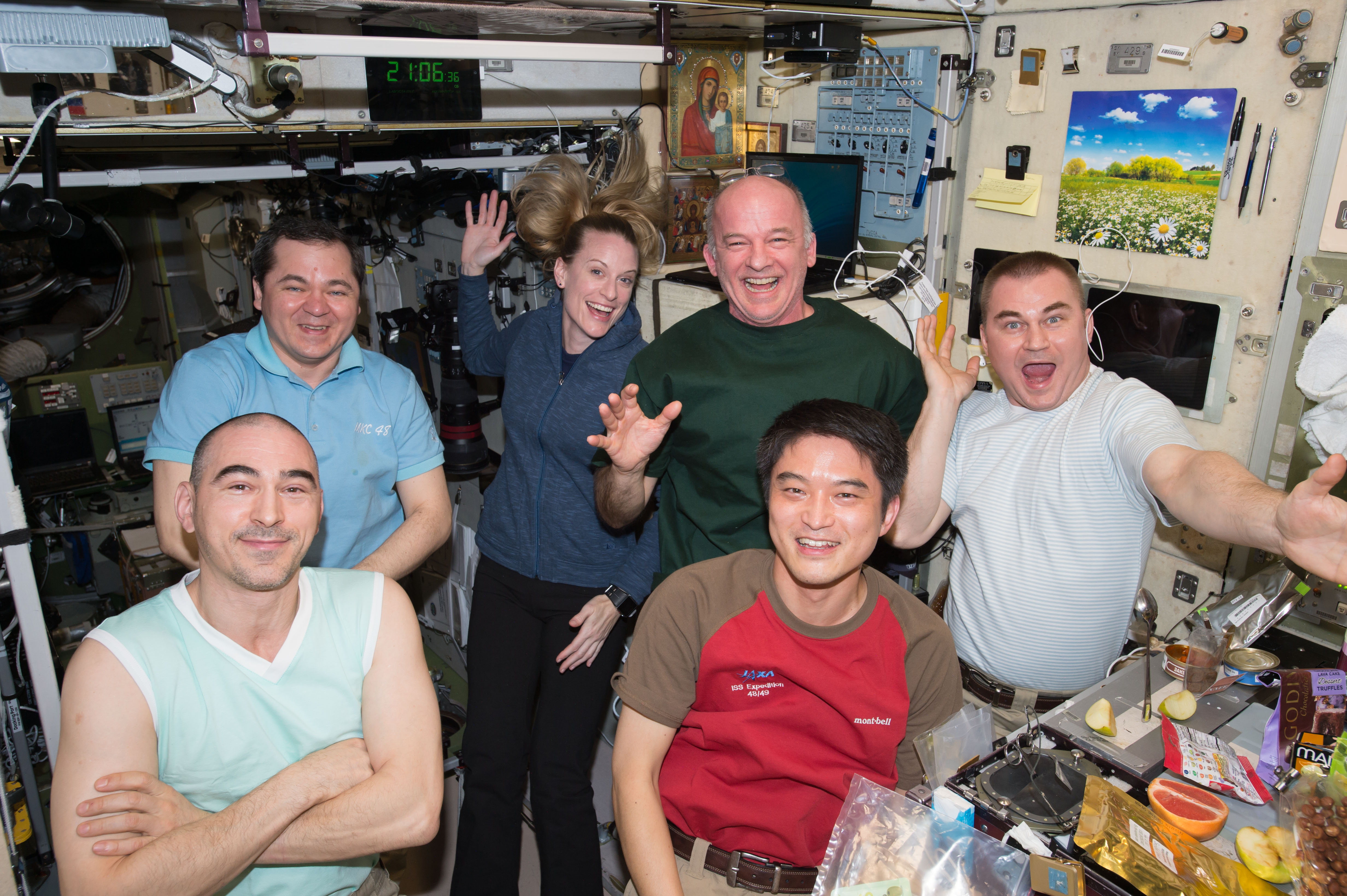 ISS-48 Crew members in the Zvezda service module sharing a light moment and a meal