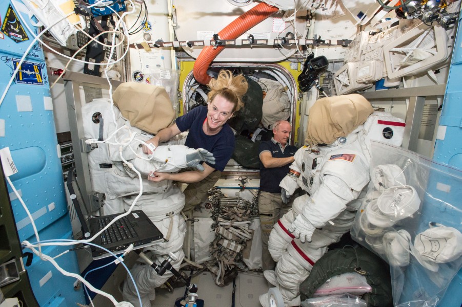 ISS-48 Kate Rubins and Jeff Williams outfit spacesuits inside the Quest airlock